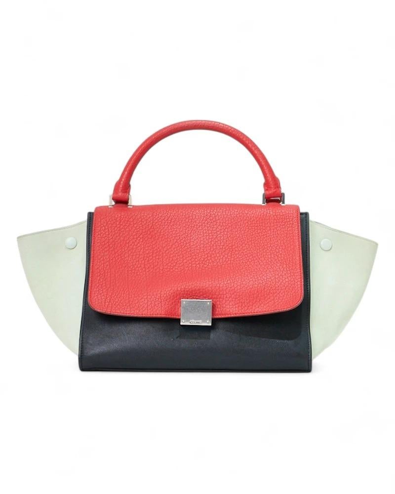 Borsa firmata Celine, modello Trapeze nella misura medium, realizzata in pelle tricolor con hardware argento. Dotata di una patta con chiusura ad incastro e una interna con chiusura a zip, internamente rivestita in pelle verde con comode tasche, la