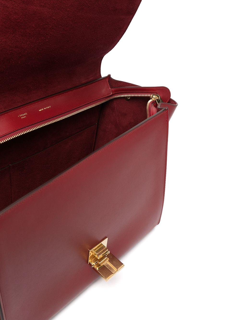 Exquisitely minimalist and modern, this brand new Céline Trapeze handbag embodies the sensibility of Phoebe Philo's Céline. Its smooth, burgundy red leather is quietly accented with a gold-toned clasp, and features has one zipped pocket on the back