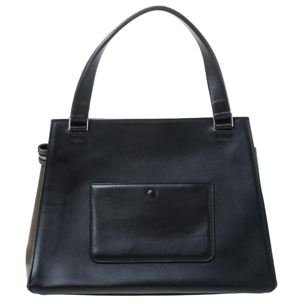 This Celine Edge bag is not only visually magnificent but also functional. It has been crafted from quality leather and styled with a silhouette that is classy and posh. The tri-colored bag has a top handle and a top zipper that reveals a spacious