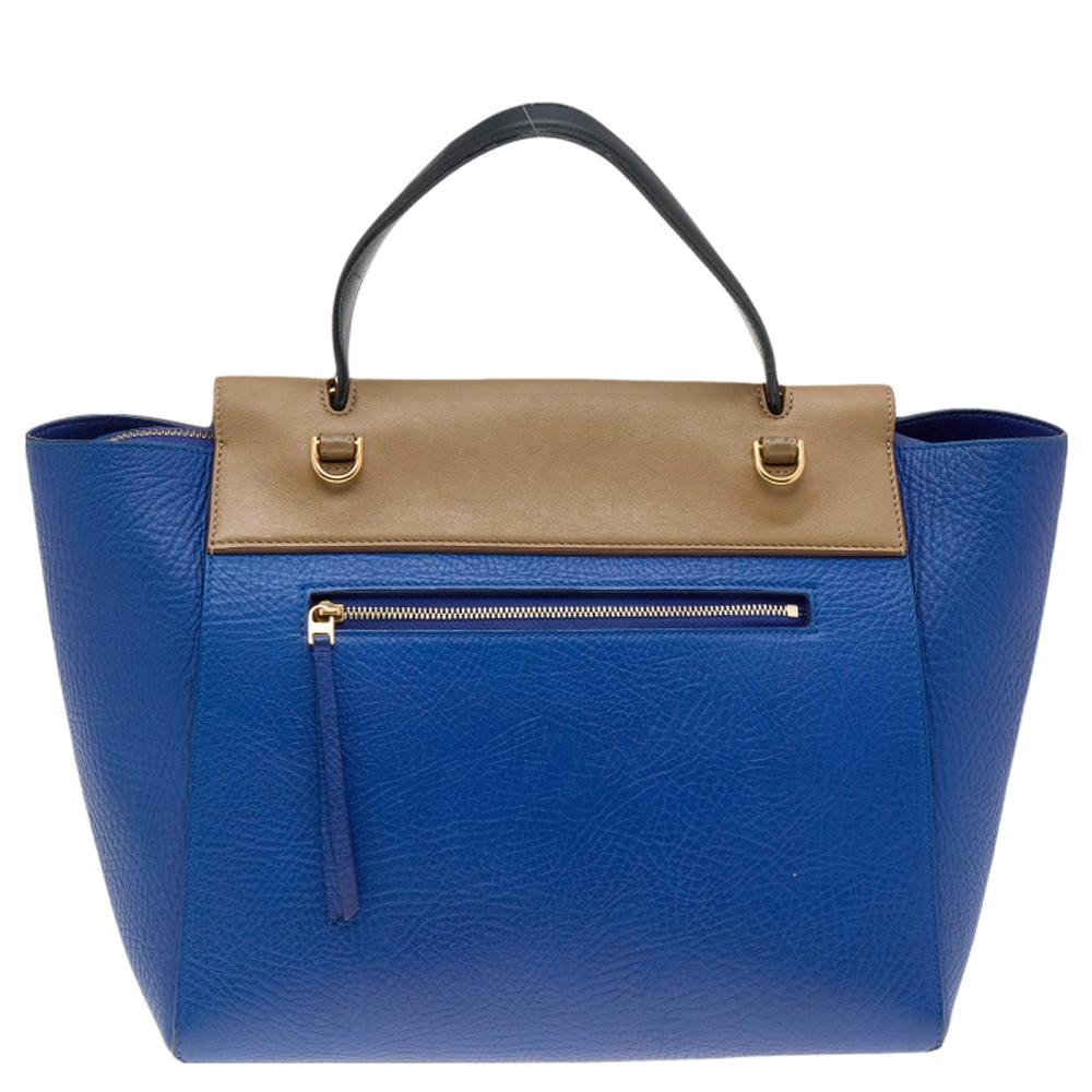 Bags from Celine are symbols of excellent craftsmanship and timeless design. This creation has been crafted from leather and styled with a front tuck-in flap and knotted belt details. It flaunts a single top handle and a well-spaced interior that