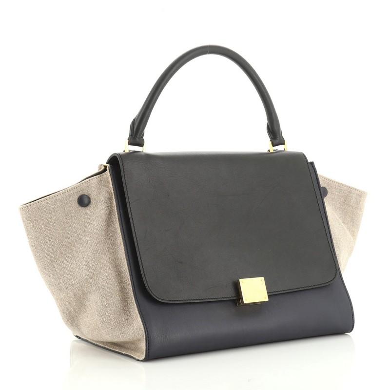 This Celine Tricolor Trapeze Bag Leather Medium, crafted from brown and neutral leather, features top looped handle, exterior back zip pocket, side snap closures, and gold-tone hardware. Its square flip-lock and zip closure opens to a neutral fabric