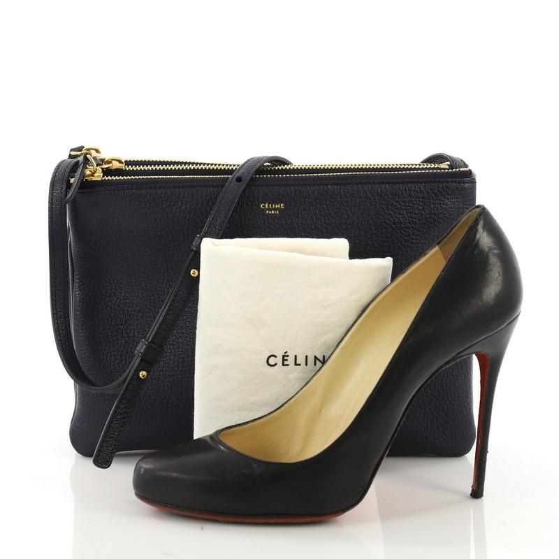 This Celine Trio Crossbody Bag Leather Large, crafted from navy leather, features an adjustable shoulder strap and gold-tone hardware. Its triple zip closures open to a navy microfiber interior. **Note: Shoe photographed is used as a sizing