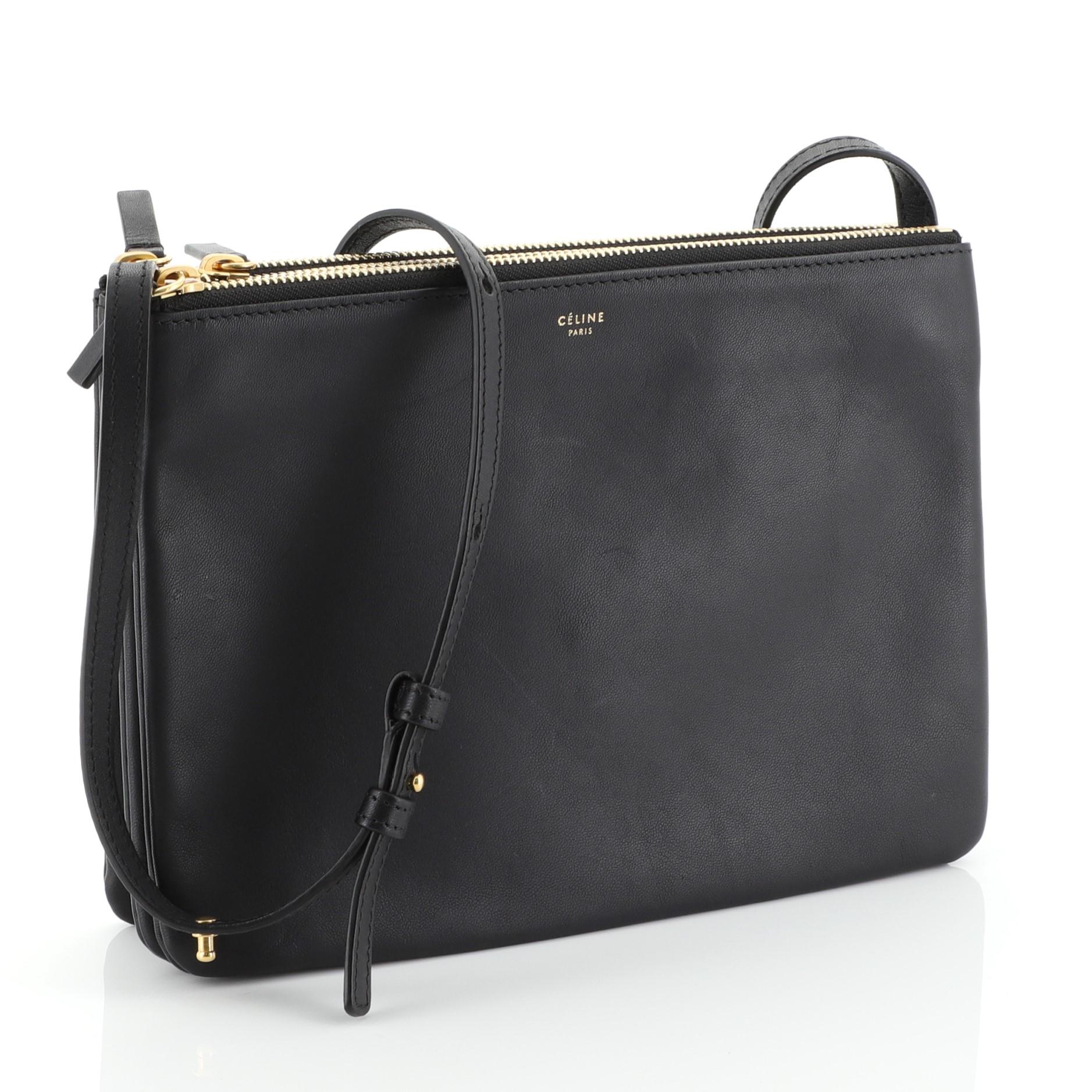 This Celine Trio Crossbody Bag Leather Large, crafted from black leather, features adjustable shoulder strap, snap buttons that easily detaches three pouches converting the bag into singular clutches, and gold-tone hardware. Its top zip closures