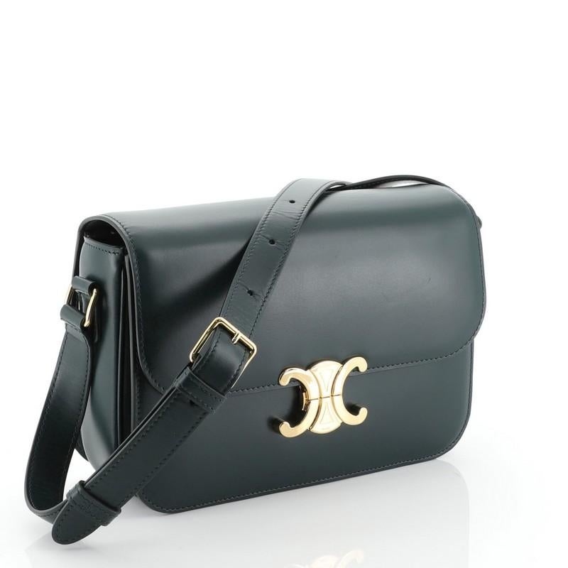 This Celine Triomphe Shoulder Bag Smooth Calfskin Medium, crafted in green leather, features an adjustable leather strap, Triomphe clasp and gold-tone hardware. Its clasp closure opens to a green leather interior. 

Estimated Retail Price: