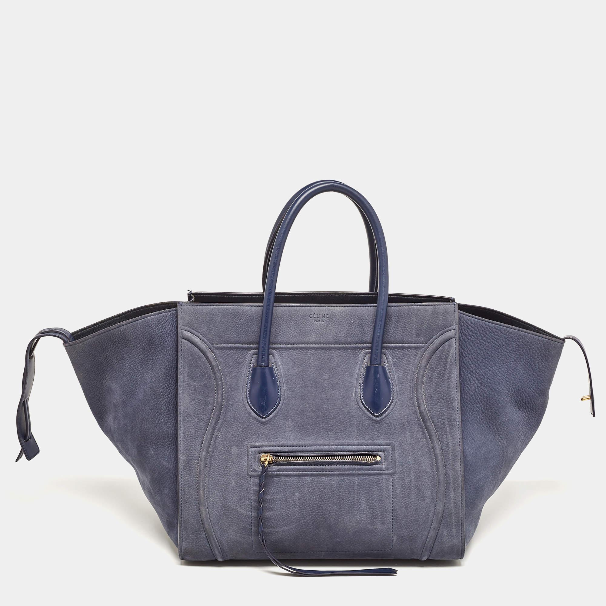 The phantom by Celine is a modernized update of the luggage bag by the brand. This tote has been constructed from nubuck leather and the design is highlighted with a wide wingspan, front zipper pocket, and brand detailing on the front. The dual