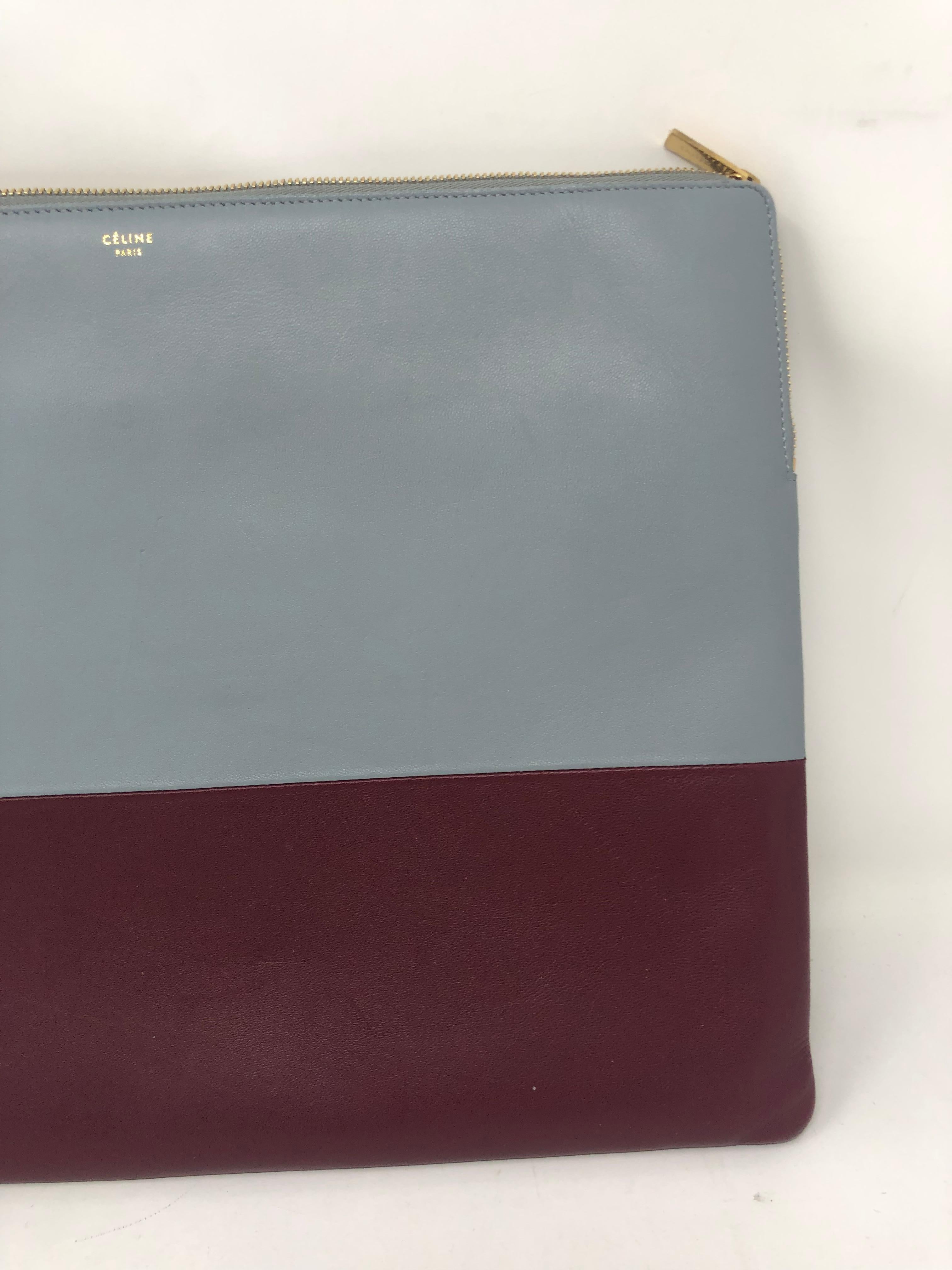 Celine two-tone leather clutch. Light blue and burgundy color. Gold hardware. Can hold a laptop. Nice work bag or evening clutch.  Good condition. Guaranteed authentic. 