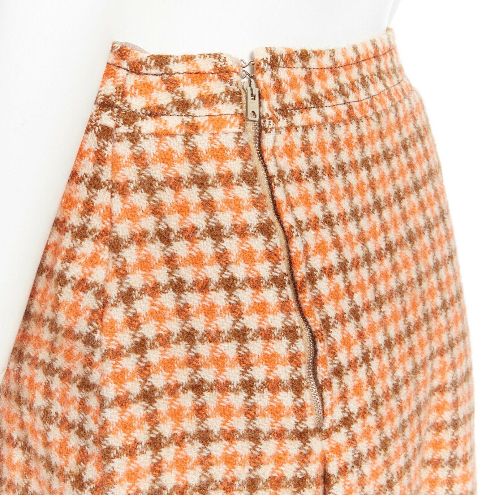 CELINE Vintage 80's orange check pleat skirt leather horse bit cuff FR44 XXL 
Reference: TGAS/A03271 
Brand: Celine 
Designer: Phoebe Philo 
Material: wool 
Color: Orange 
Pattern: Check 
Closure: Zip 
Extra Detail: Asymmetrical pleated skirt.