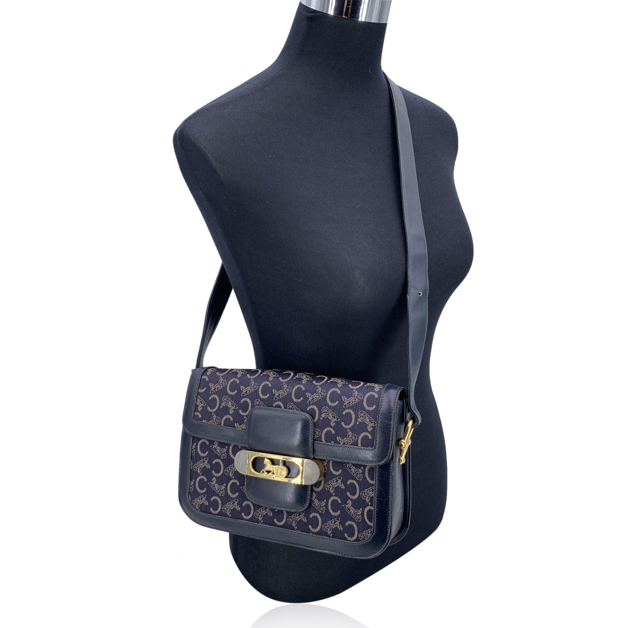 Elegant et discrètement iconique, ce sac à bandoulière vintage A.I.C. de Celine évoque le luxe discret d'une époque révolue. Réalisé en toile classique A.C.C. et encadré d'une riche garniture en cuir bleu marine, il respire la sophistication