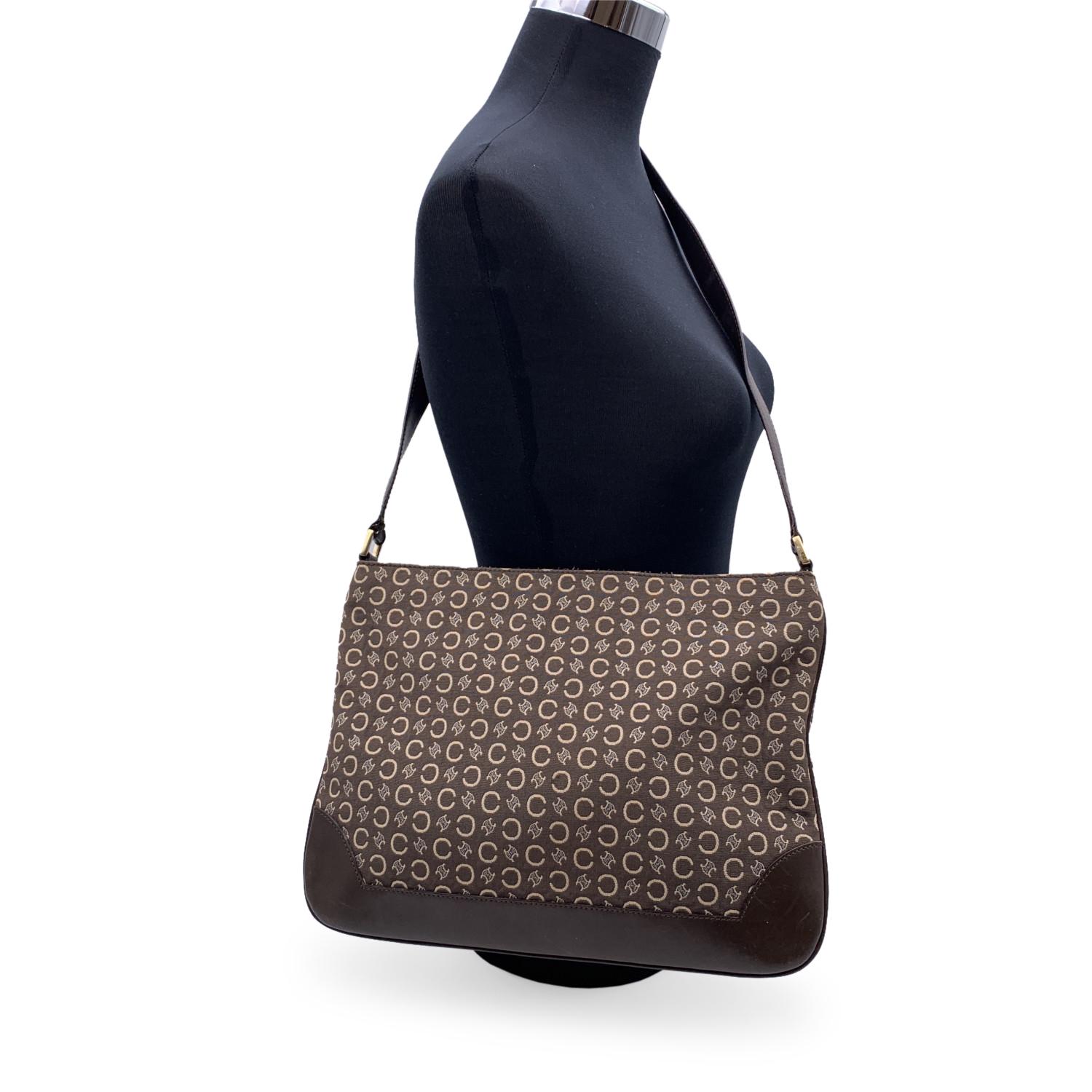 Celine brown C Macadam canvas shoulder bag. I The bag features C and macadam pattern and brown leather trim and shoulder strap. Upper zipper closure. Brown canvas lining.1 side zip pocket inside. 'Celine' tag inside. Serial number on the reverse of