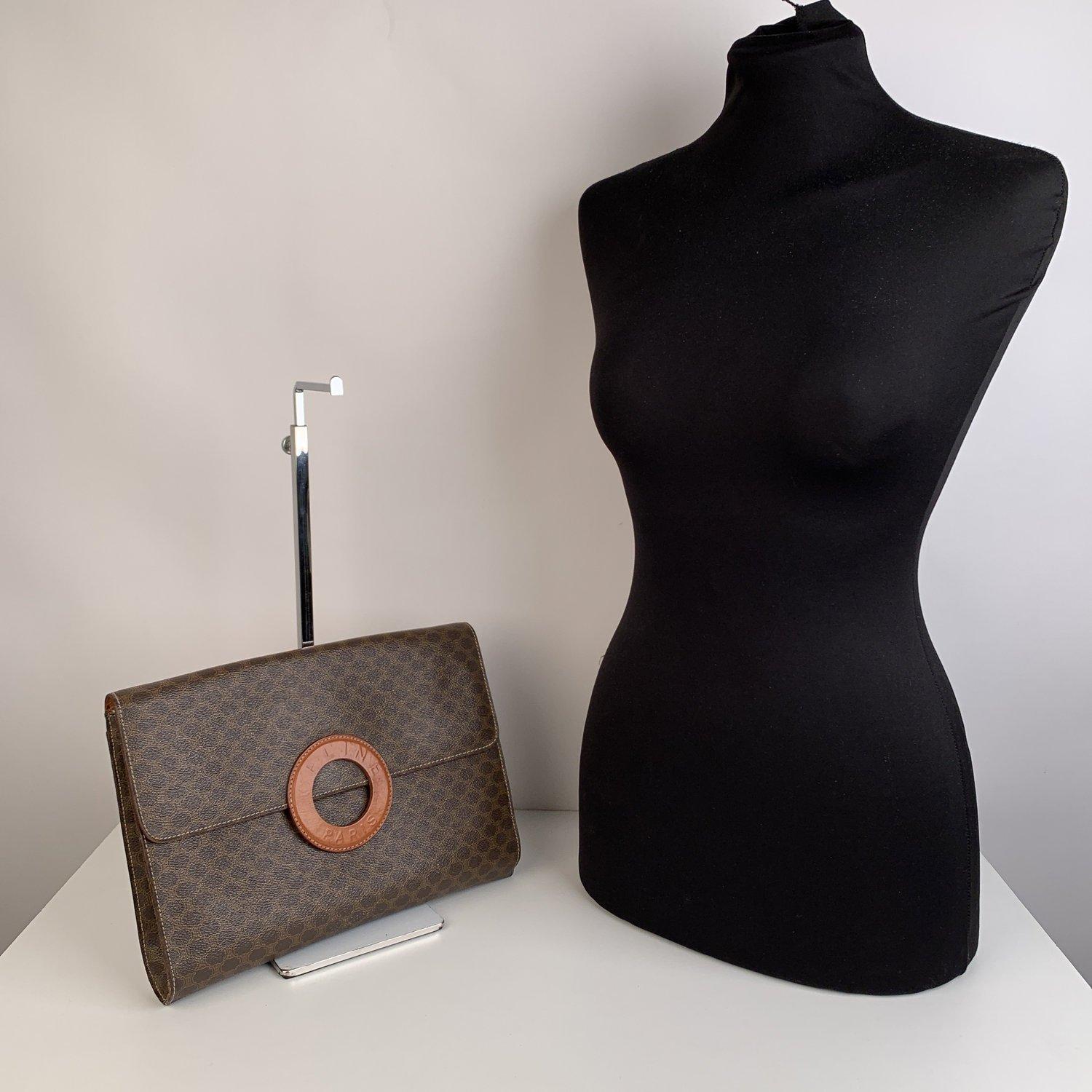 MATERIAL: Canvas COLOR: Brown MODEL: Clutch Bag GENDER: Women SIZE: Small Condition B - VERY GOOD Some light wear of use - some wear of use on bottom corners (the left corner shows 2 missing stitch). Some darkness and light scratches on the reverse