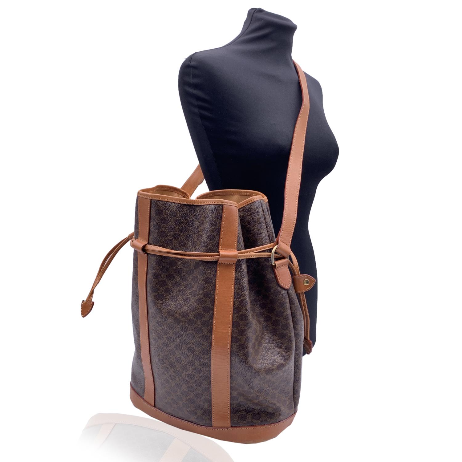 Celine Brown 'Macadam' Canvas Bucket Bag with genuine leather trim and shoulder Straps. Drawstring closure. Tan lining. 1 side zip pocket inside. 'Celine Paris ' and 'Made in Italy' engraved inside


Details

MATERIAL: Canvas

COLOR: Brown

MODEL: