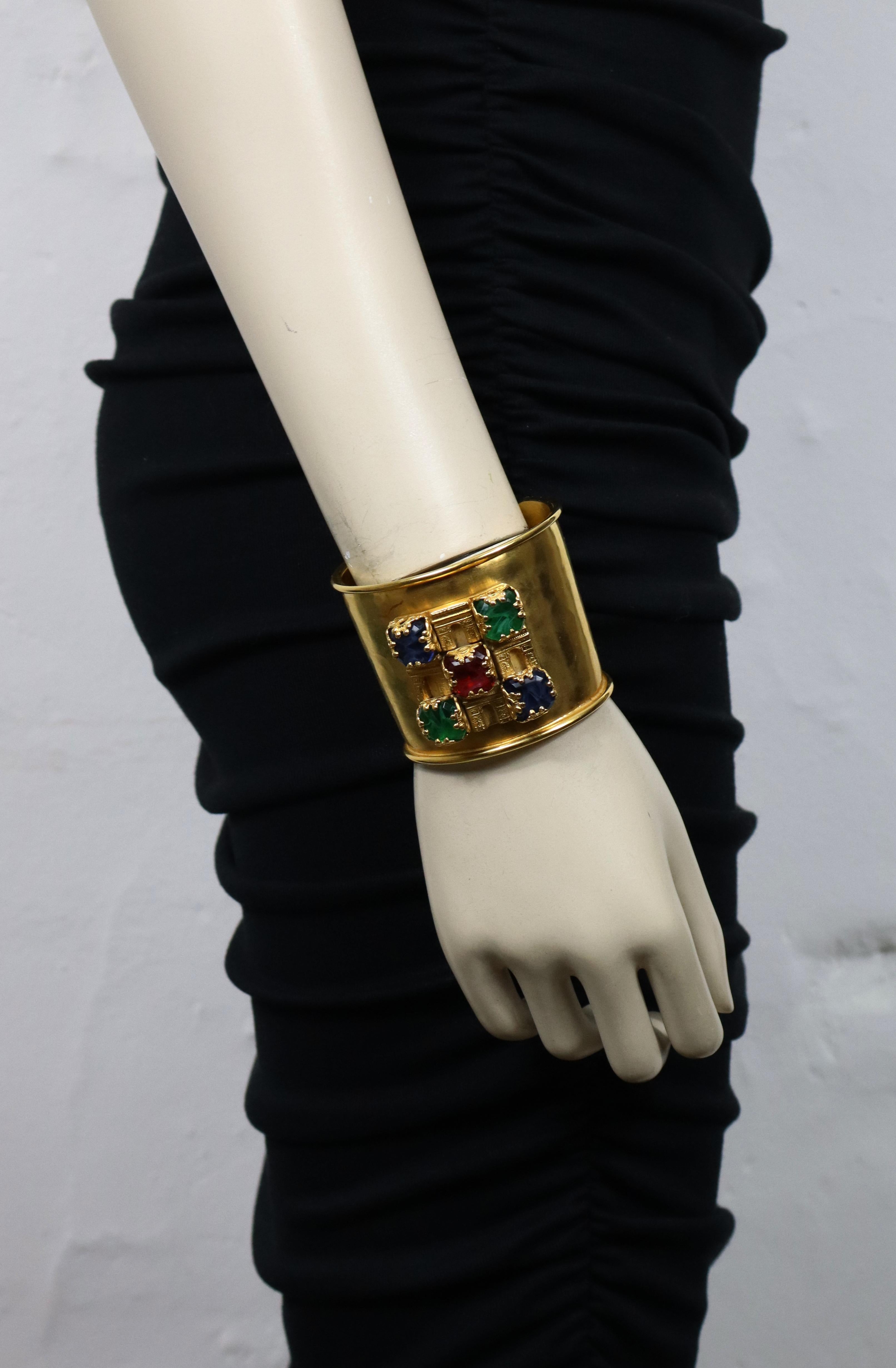 CELINE vintage gold tone hammered cuff bracelet embellished with four Paris Triumphal Arches adorned with marbled blue, red and green glass cabochons.

Embossed CELINE Made in Italy.
Private sale mark on the signature coin (not visible when the