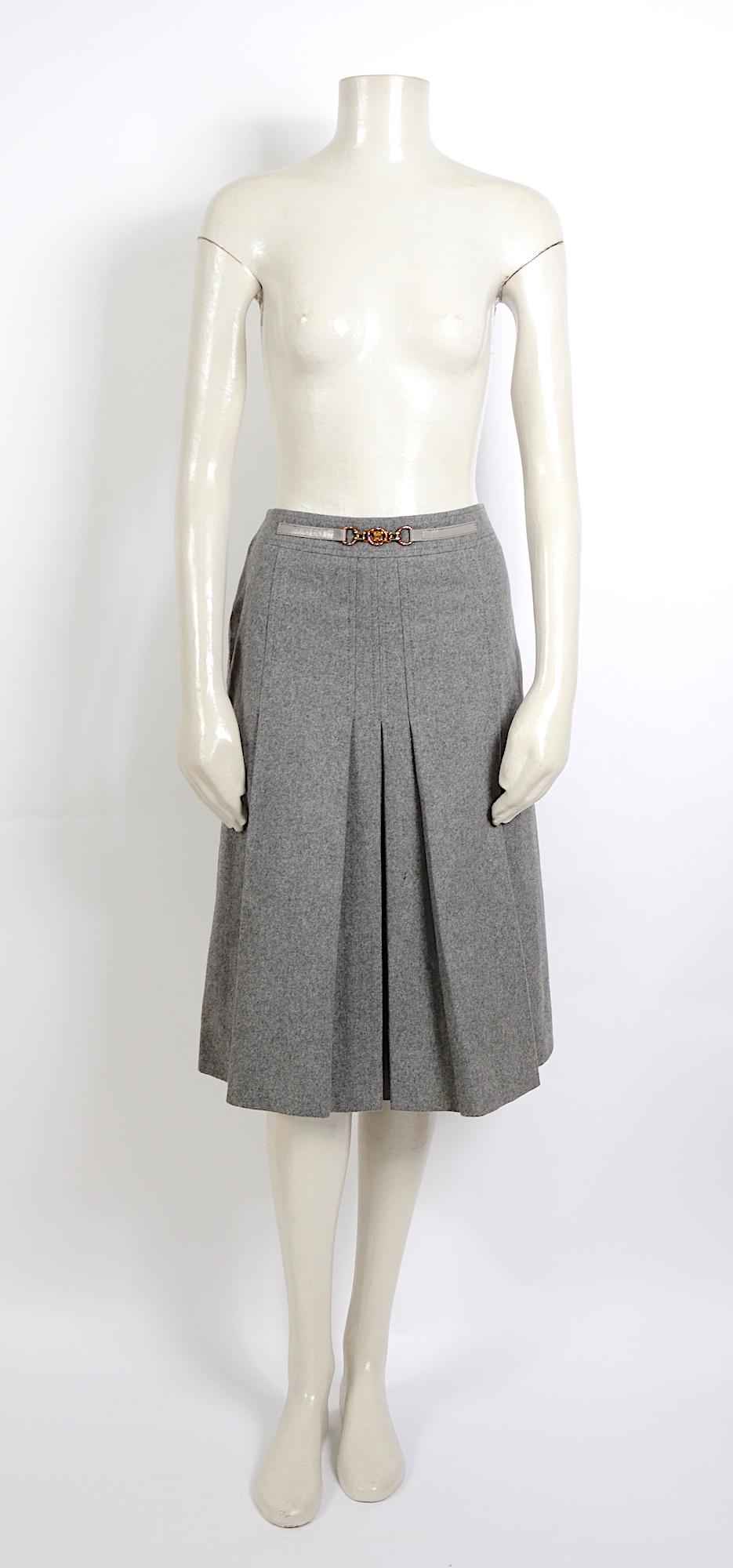 Céline Paris grey wool pleated skirt with attached belt logo belt detail.
The front is adorned with a fixed grey leather belt with a gold buckle that features the Celine logo. The skirt is lined and in good vintage condition.
the skirt was pinned on