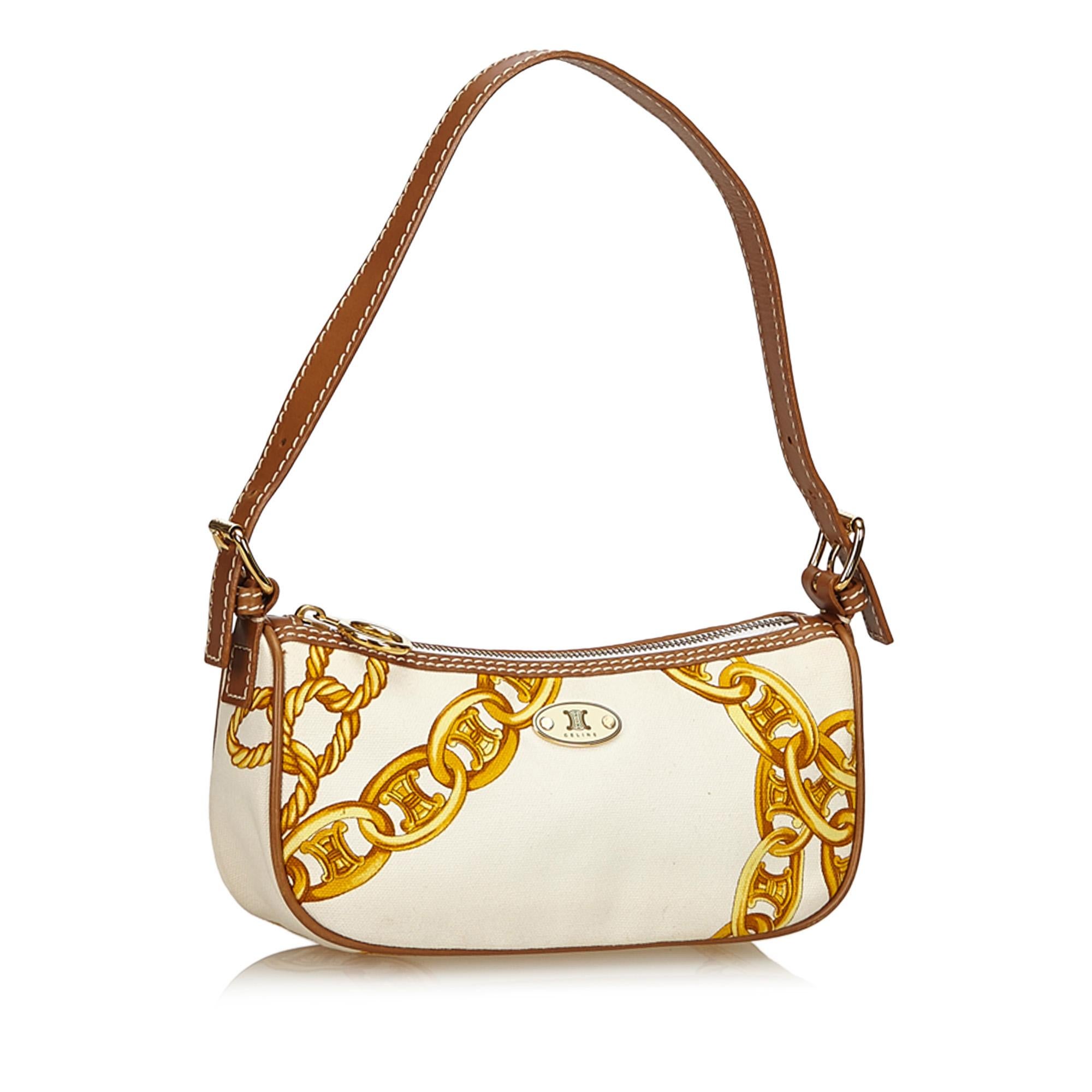 This baguette features a canvas body with leather trim and gold chain print, flat leather strap, top zip closure, and interior slip pocket. It carries as B+ condition rating.

Inclusions: 
This item does not come with