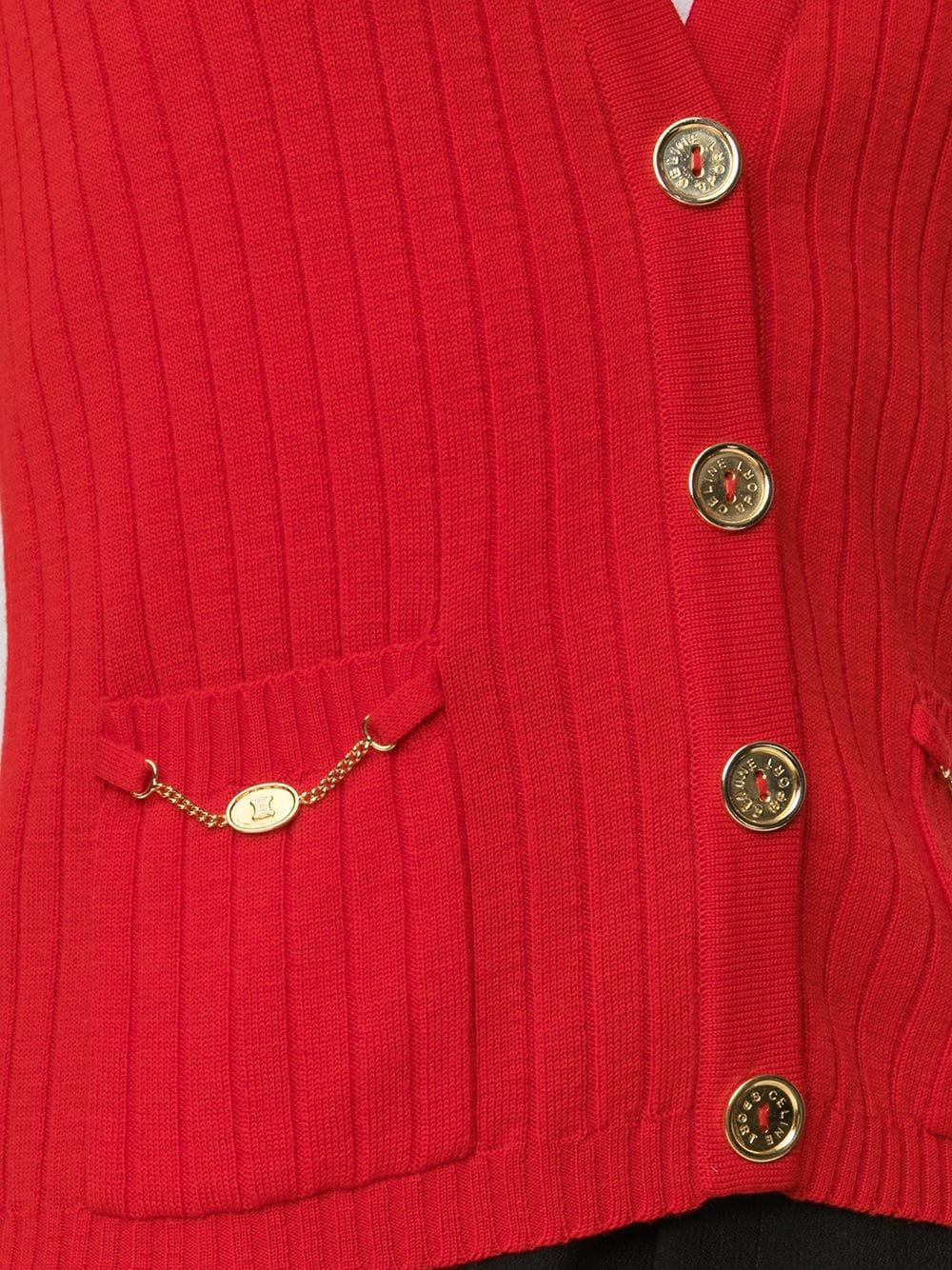 Rote Vintage-Weste von Céline mit V-Ausschnitt und doppelten Taschen vorne. Mit goldfarbenen, gravierten Knöpfen (der innere Ersatzknopf ist noch vorhanden) und kleinen goldenen Ketten an den Taschen.	

Farbe: Rot/Gold	

Zusammensetzung: 100%