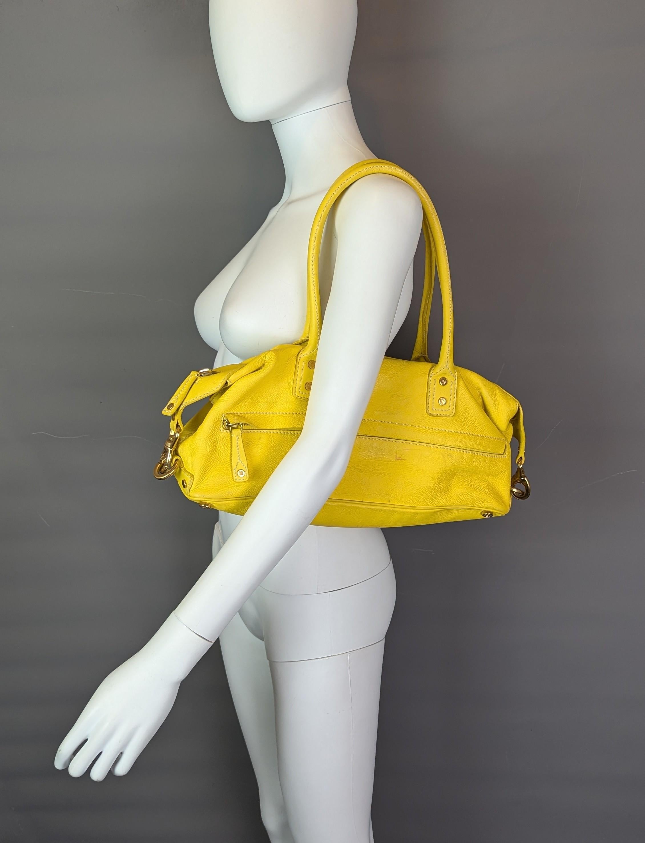 Un elegante bolso barril vintage Celine de piel de becerro amarilla.

Está fabricada en una preciosa y suave piel de ternero teñida, totalmente forrada en una lona beige con herrajes en tono dorado.

Tiene grandes asas superiores adecuadas para