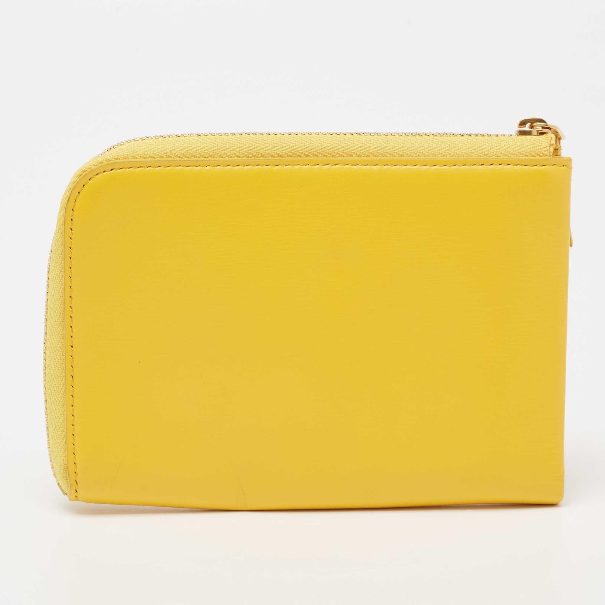 Compact and handy, this Celine wallet will work well as an everyday accessory. It has been crafted from yellow leather, and the creation is highlighted with the brand logo on the front and secured by a gold-tone zipper. The interior is divided into
