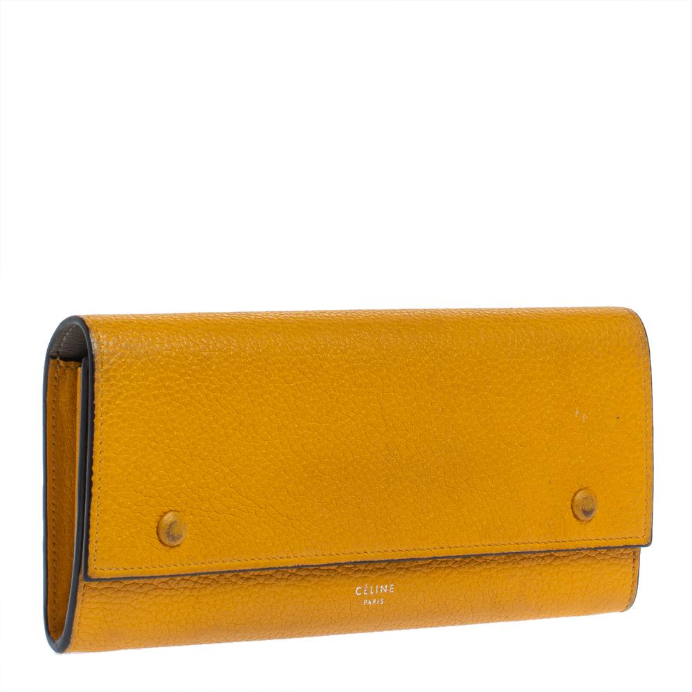 Designed to perfection from leather, this wallet will be your go-to accessory. From the house of Celine, it features a front flap accented with snap button fastening along with multiple card slots and a zip pocket. Adorned in a yellow shade, this