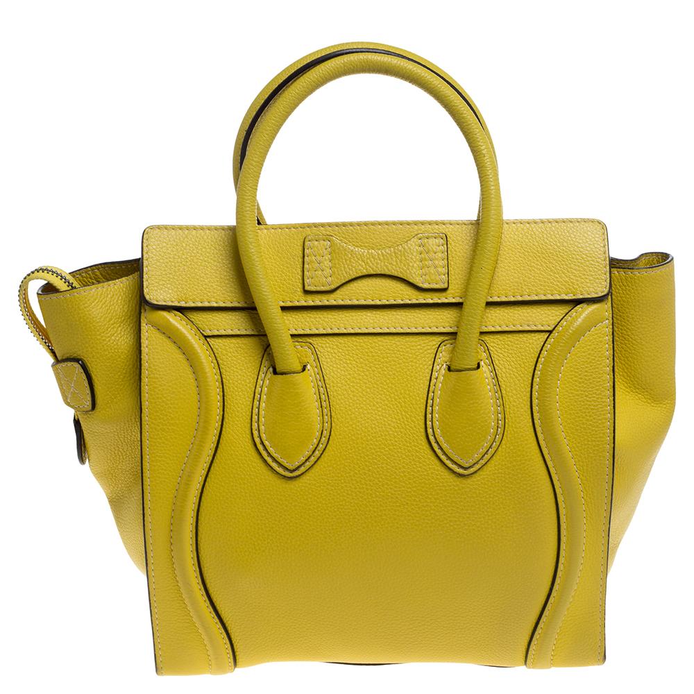 The mini Luggage tote from Celine is one of the most popular handbags in the world. This tote is crafted from leather and designed in a yellow shade. It comes with rolled top handles, silver-tone hardware, and a front zip pocket. The bag is equipped
