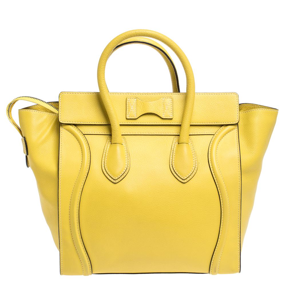 The mini Luggage tote from Celine is one of the most popular handbags in the world. This tote is crafted from leather and designed in a yellow shade. It comes with rolled top handles and a front zip pocket. The bag is equipped with a well-sized