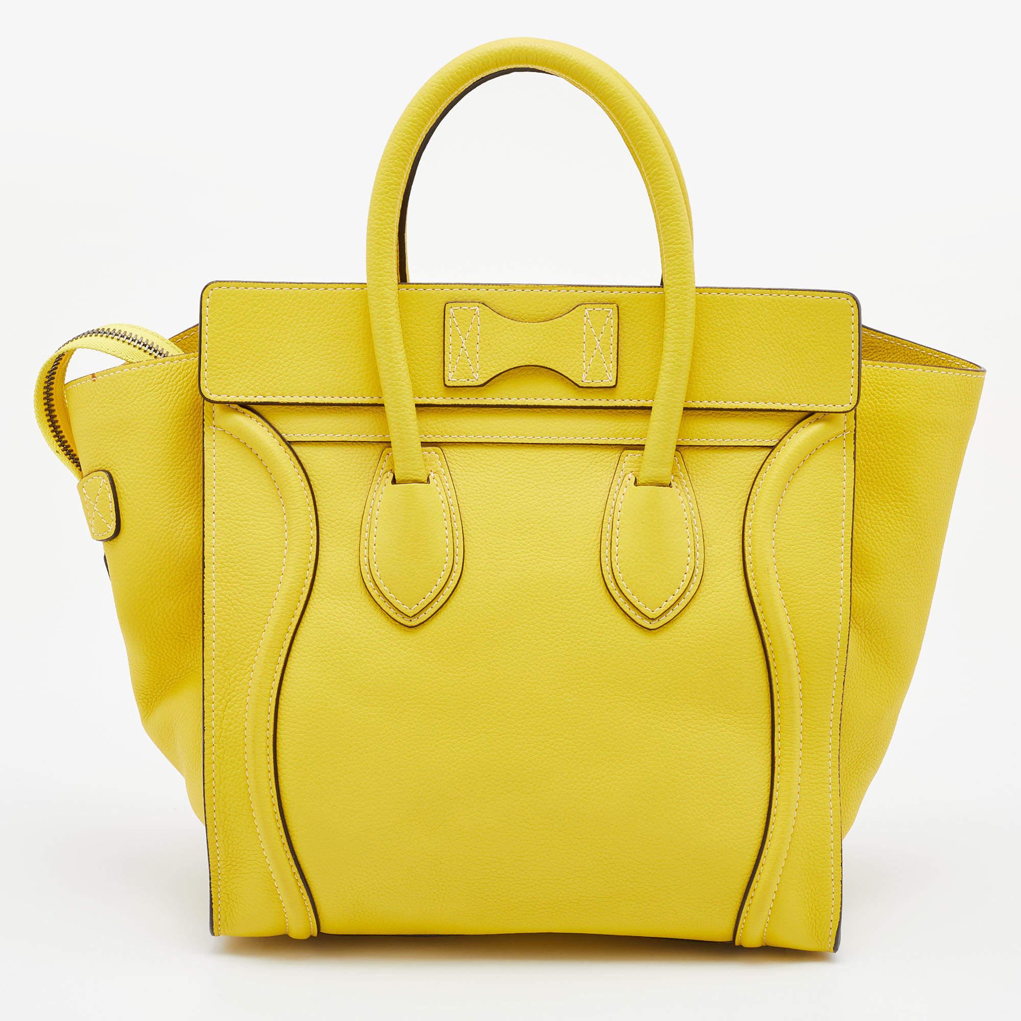 The mini Luggage tote from Celine is one of the most popular handbags in the world. This tote is crafted from leather and designed in a yellow shade. It comes with rolled top handles, protective metal feet, and a front zip pocket. The bag is