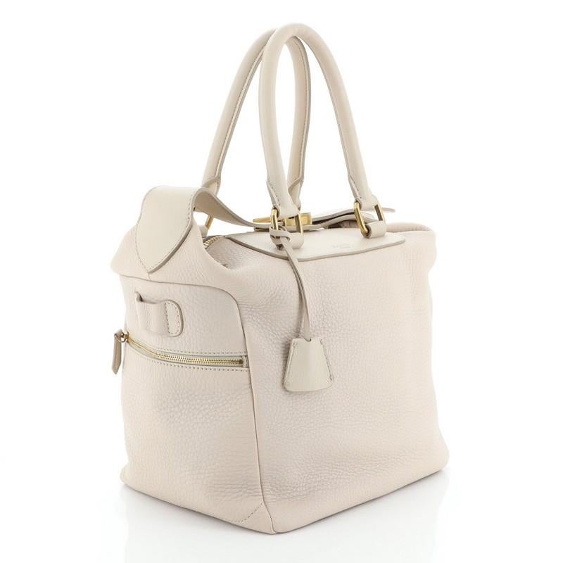 This Celine Zip Top Satchel Leather Medium, crafted from neutral leather, features dual rolled handles and gold-tone hardware. Its zip closure opens to a neutral fabric interior. 

Condition: Very good. Loss of shape on exterior, minor wear on base