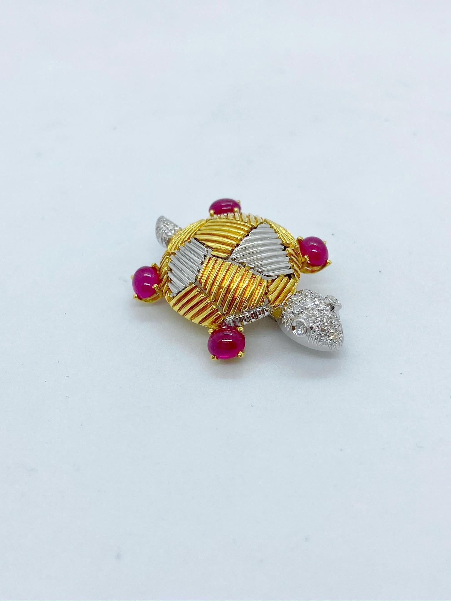 Adorable turtle brooch designed with a geometric pattern in 18 karat white and yellow gold. The turtles head and tail are pave set Diamonds and his four feet are set with round cabochon Rubies. He measures 1 1/4