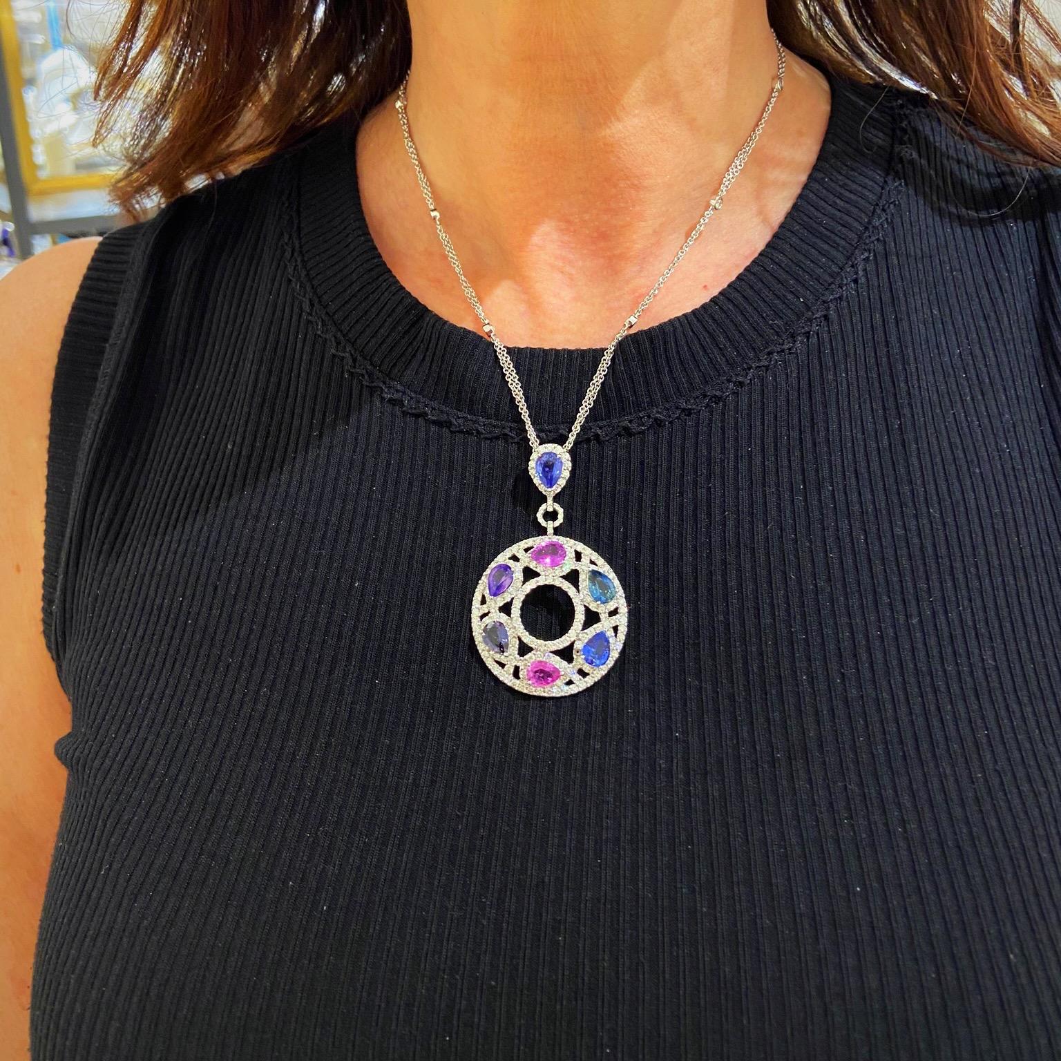 A magnificent 18 karat white gold and Diamond pendant. The pendant is set with round brilliant Diamonds in an openwork setting. Seven pear shaped Sapphires in shades of Purple, Pink and Blue are the centerpiece of this pendant. The pendant and bale