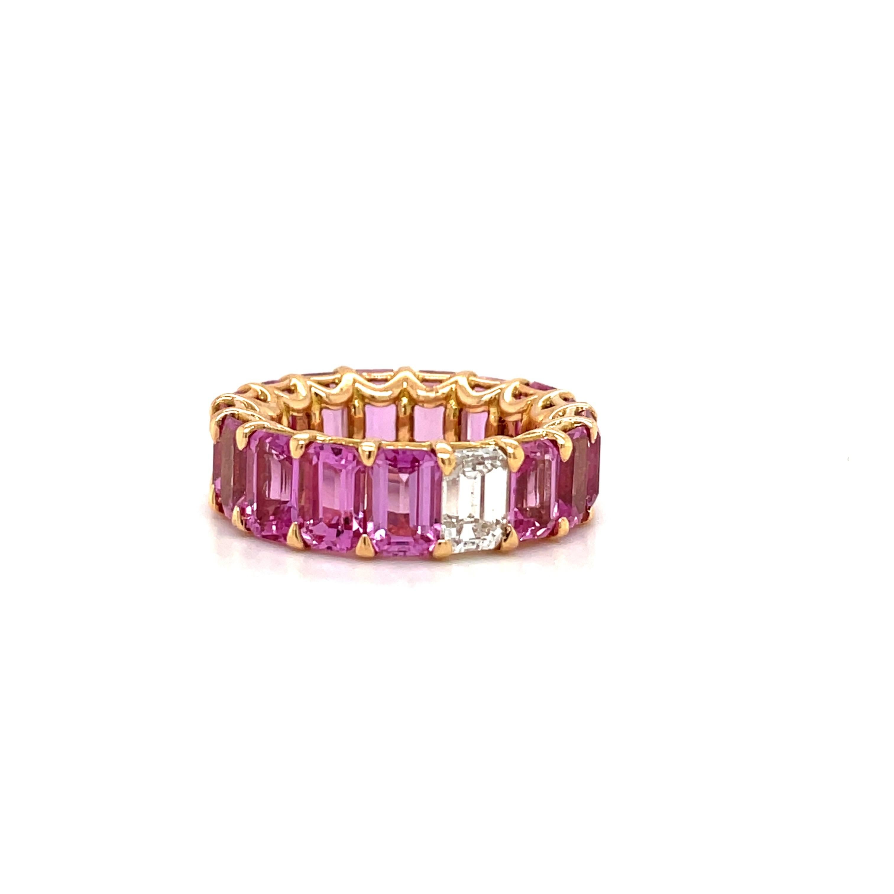 Magnificent 18 karat rose gold eternity band . This unique band is set with 16 emerald cut pink sapphires and 1 emerald cut diamond in the center. This is a shared prong setting with 