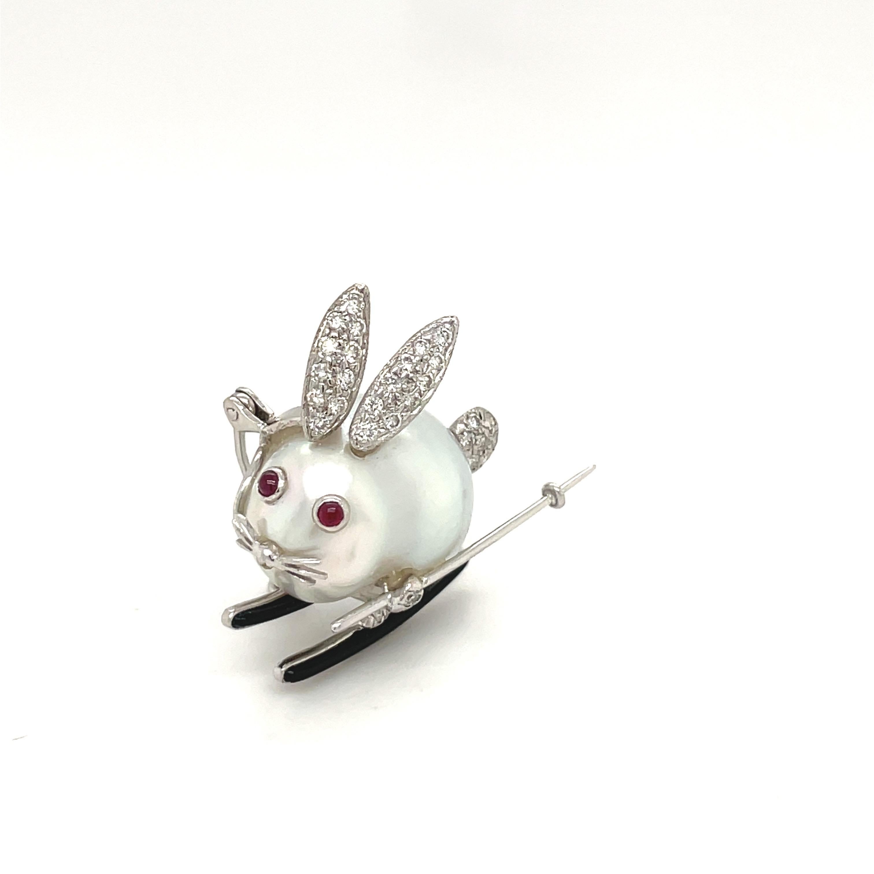 This adorable 18 karat white gold brooch is whimsically designed as a bunny. A 17mm baroque pearl is the body, with pave diamond ears and cabochon ruby eyes. The brooch measures approximately 1