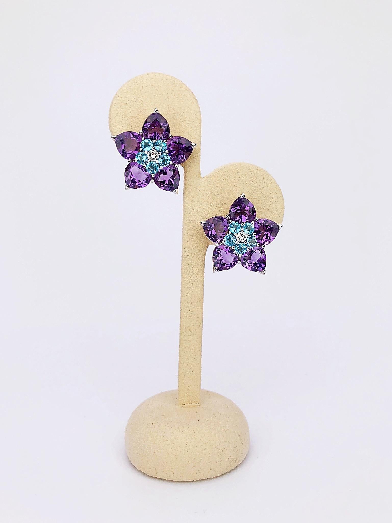 These 18 karat white gold flower earrings designed for Cellini Jewelers NYC are set with pear shaped amethyst as the petals and round blue topaz and diamond for the centers. The earrings have a post/ clip back but can be adjusted for non pierced