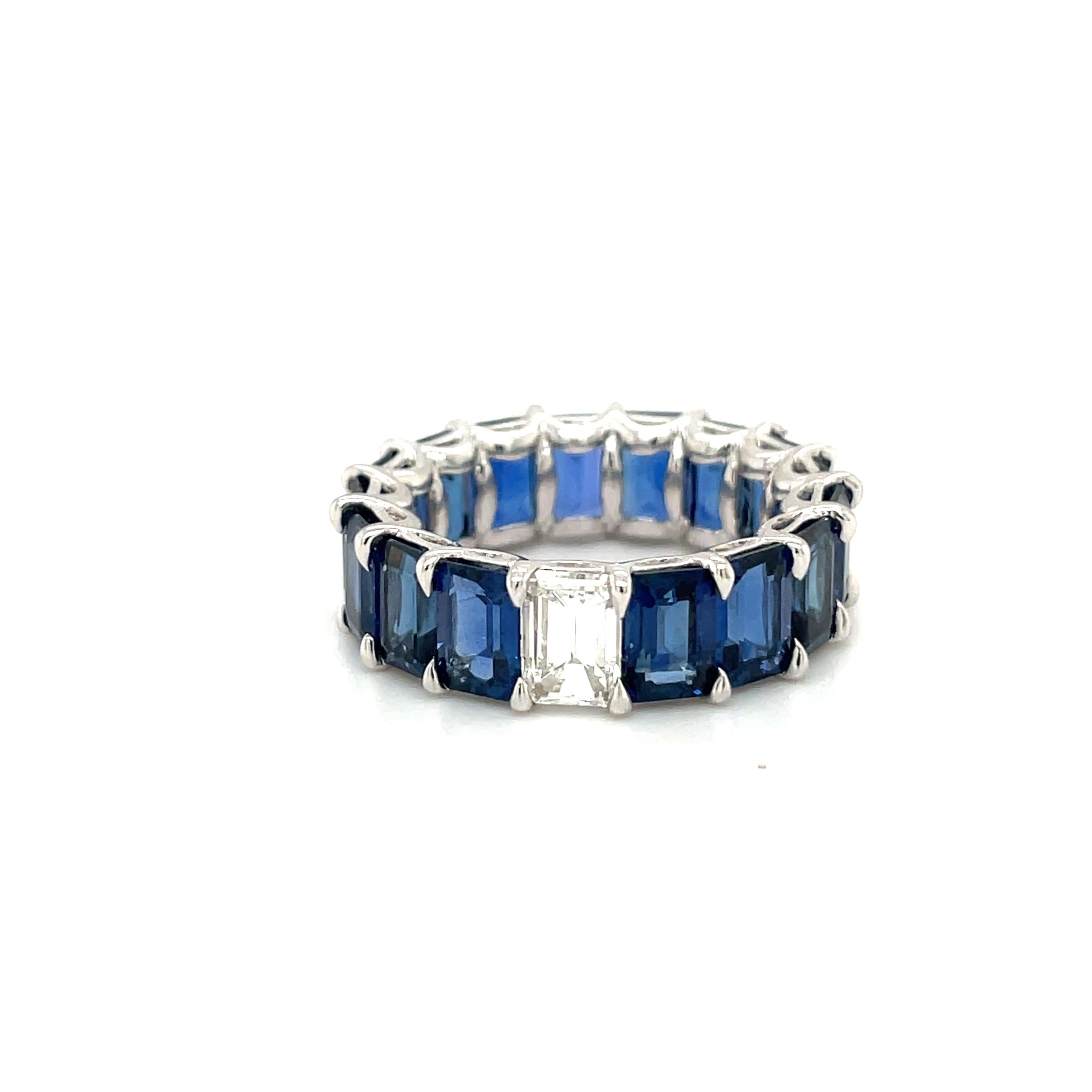 Magnificent 18 karat white gold eternity band . This unique band is set with 16 emerald cut  blue sapphires and 1 emerald cut diamond in the center. This is a shared prong setting with 