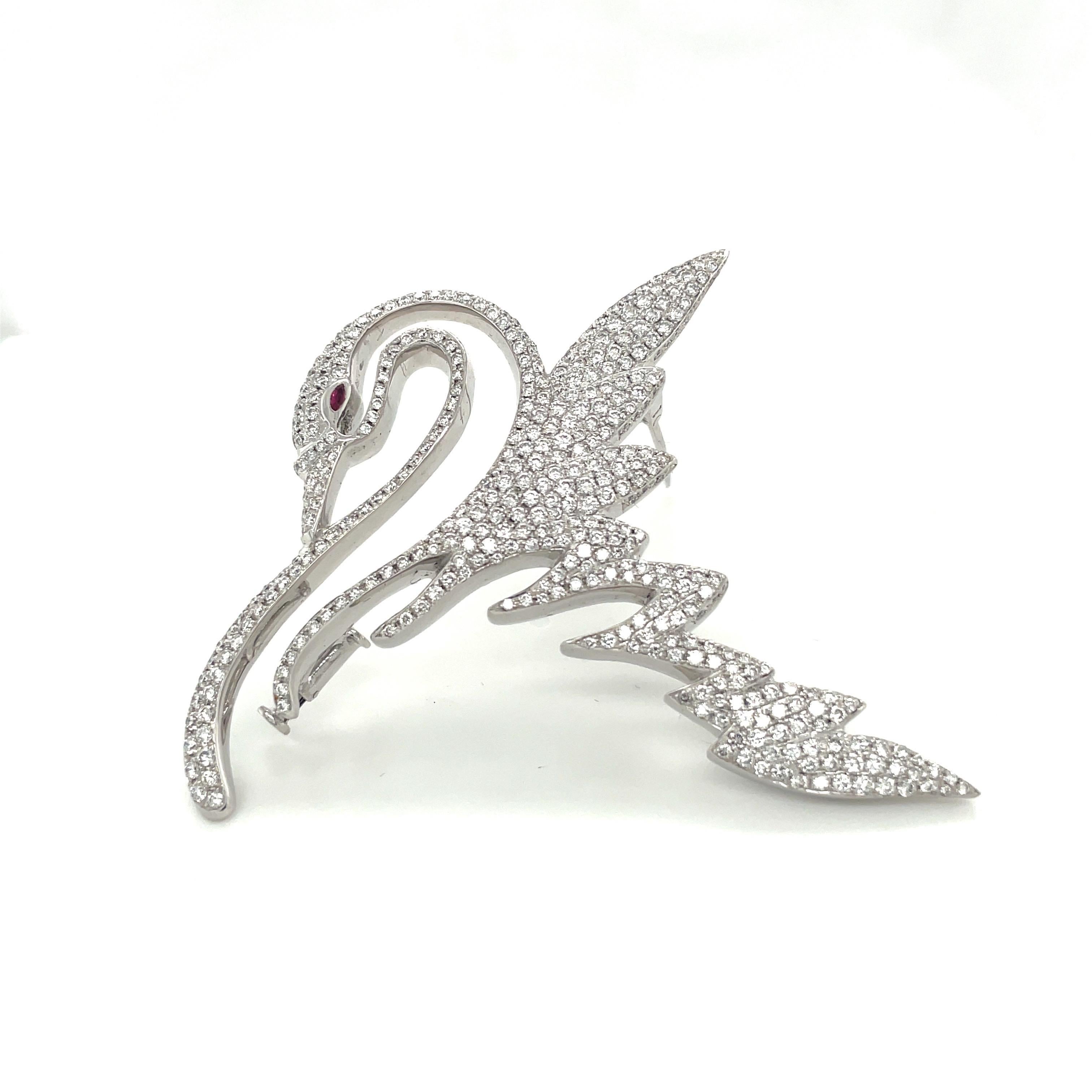 The magnificent swan brooch is designed in 18 karat white gold and is set with 4.30 carats of round brilliant diamonds. A marquise cut ruby is set as the eye. The graceful swan is 2-5/8