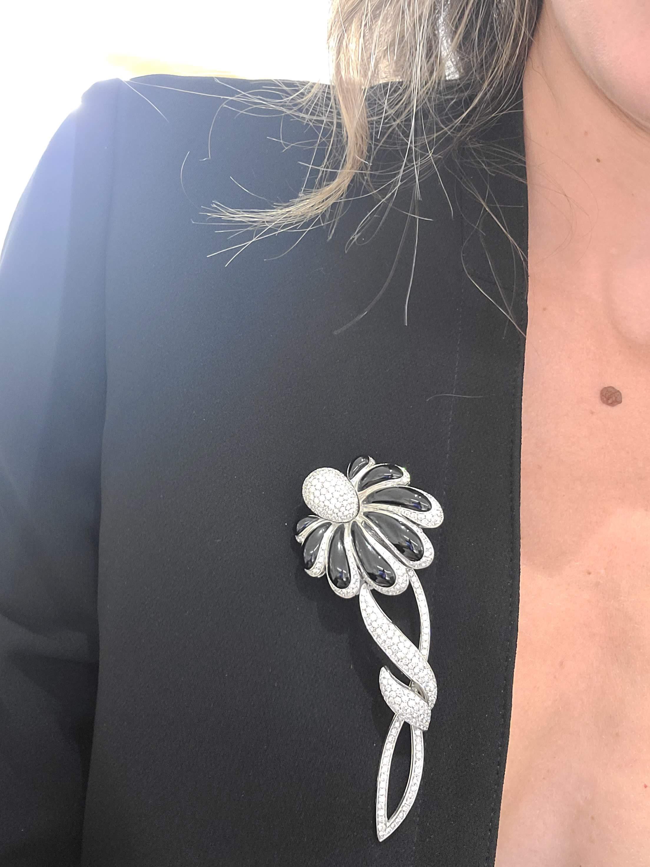 Cette broche fleur en or blanc 18 carats a été réalisée exclusivement pour Cellini en Italie par Roberto Casarin. Les pétales sont magnifiquement sertis de diamants pavés et d'onyx noir poli. La fleur est détaillée avec le bouton, la tige et les