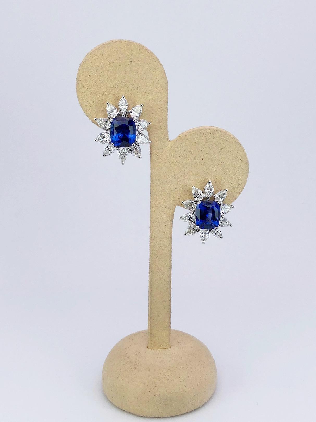 Cushion-shaped sapphires with an entourage of pear-shaped diamonds. Set in 18-karat white gold; post and clip back. The pear shaped diamonds are set in a three prong ,high low setting giving the flower like shape earrings lovely depth on the