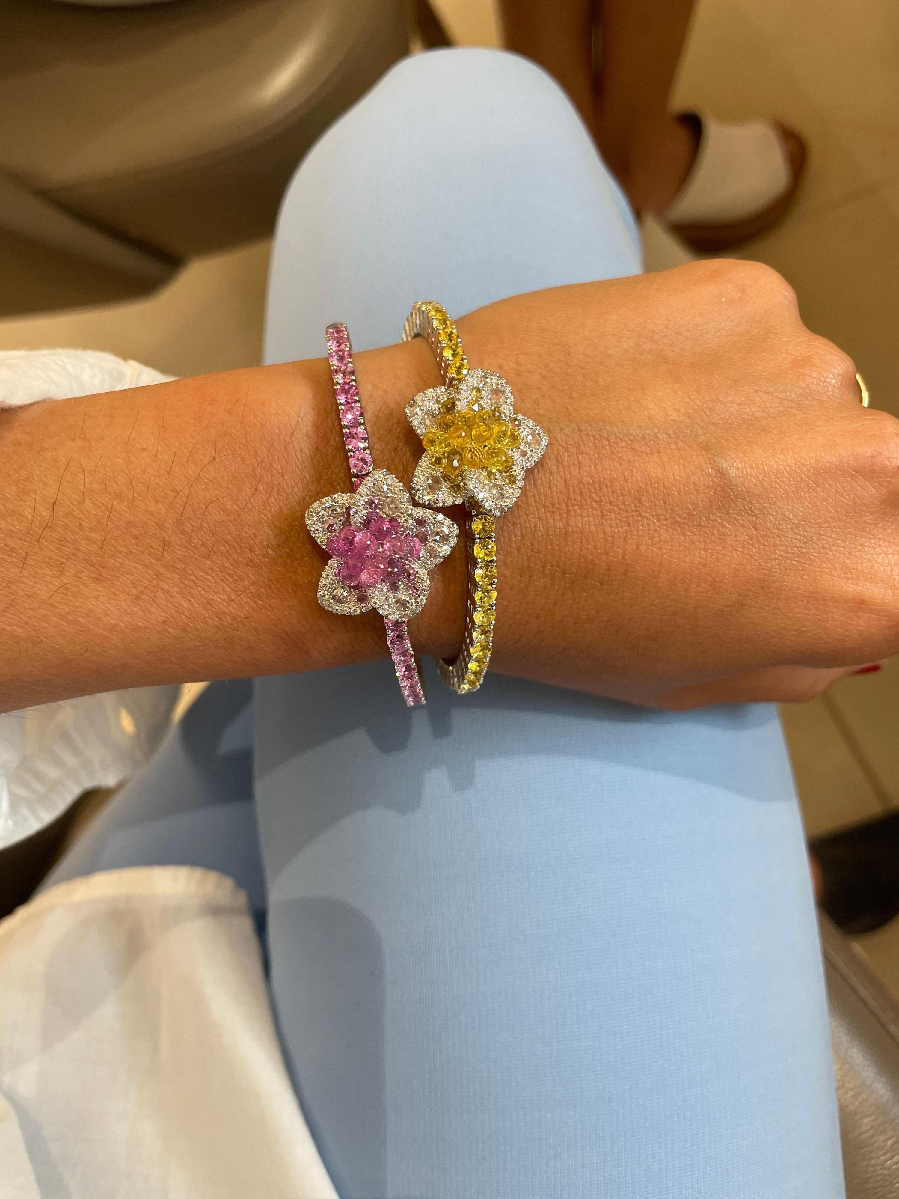 This uniquely stunning flower bracelet is composed of .87 carats of round brilliant and rose cut diamonds, and 8.66 carats round and briolette cut pink sapphires.
The briolette sapphires at the center of the diamond flower are raised , allowing them