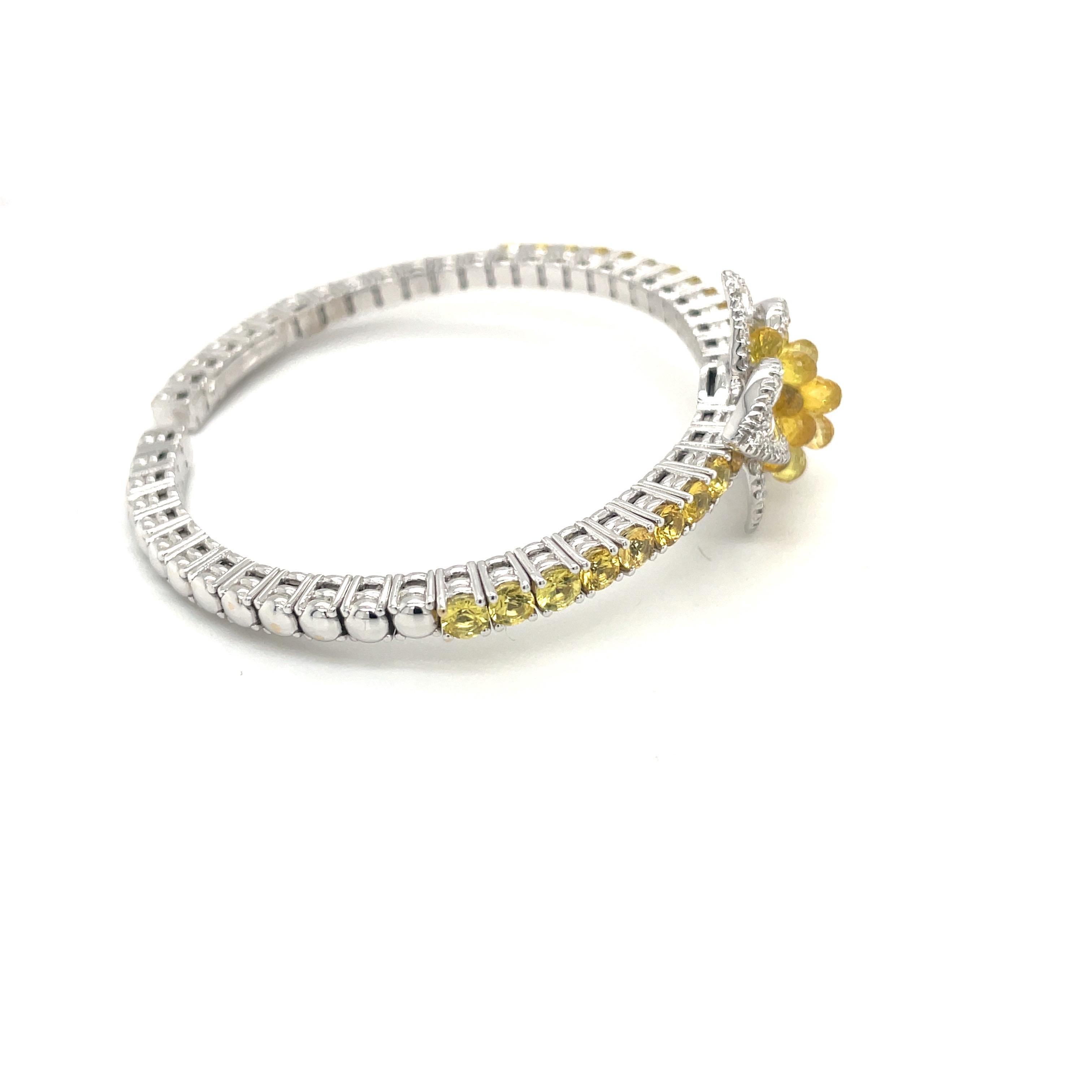 This uniquely stunning flower bracelet is composed of .87 carats of round brilliant and rose cut diamonds, and 9.21 carats round and briolette cut yellow sapphires.
The briolette sapphires at the center of the diamond flower are raised , allowing