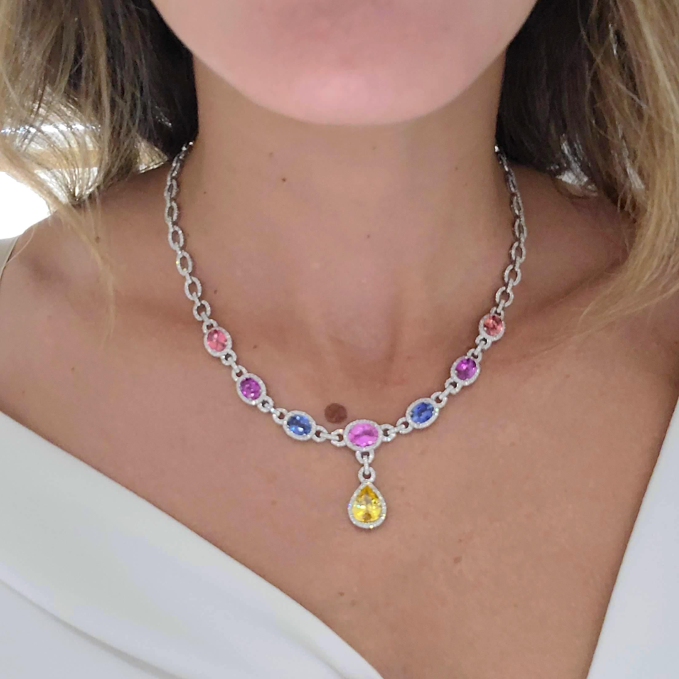 Feel like a princess in this beautifully designed 18 karat white gold necklace set with a lovely palette of Oval Sapphires .The Sapphires include Amber, Pink, & Blue. A Pear shaped Yellow Sapphire drops from the center. Each sapphire is set in a