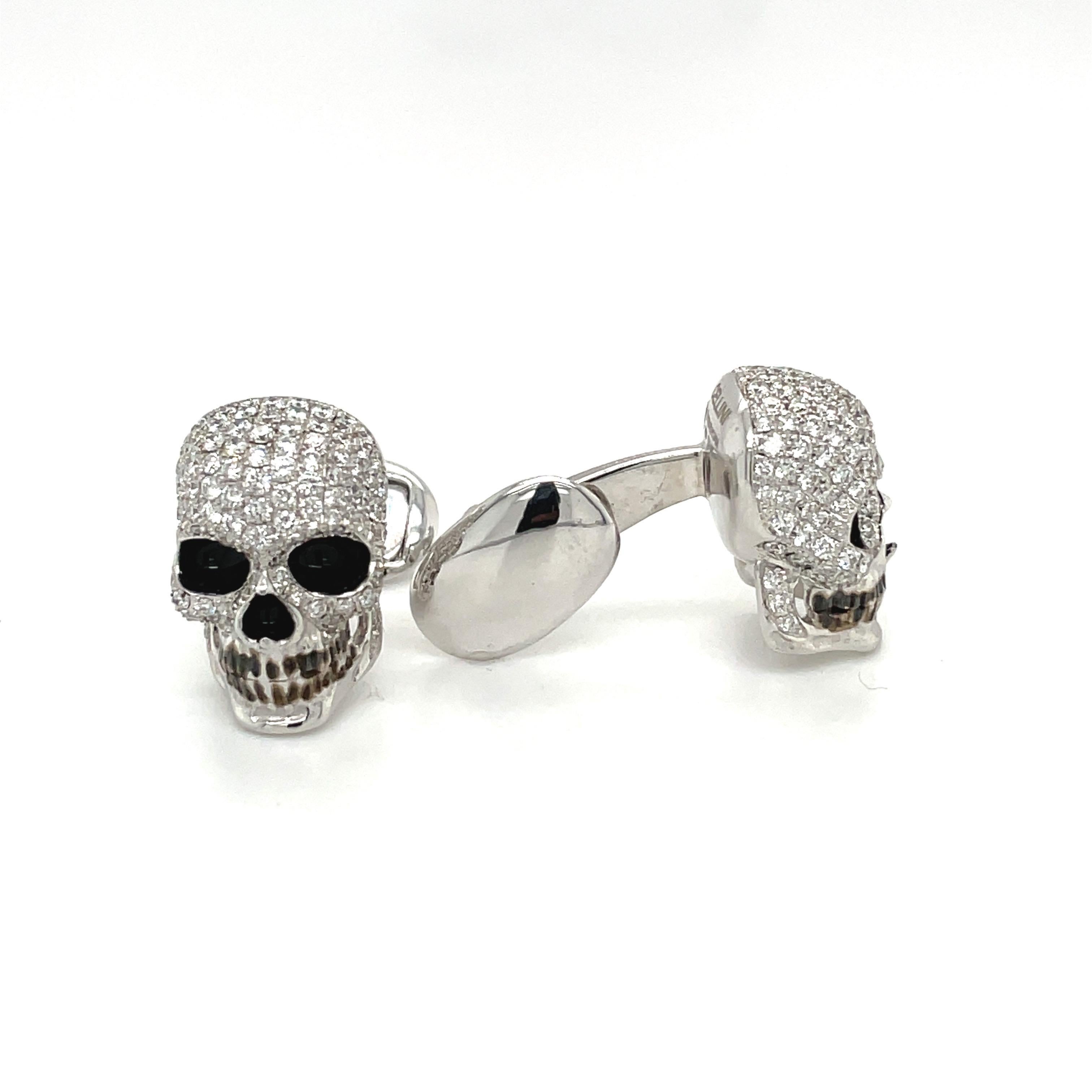 Beautifully designed 18 Karat white gold skull head cuff links. The skulls are pave set with 236 round brilliant diamonds. The hollowed out eyes and nose are enameled in black.
Stamped Cellini 750 1.25
Total diamond weight 2.50 carats