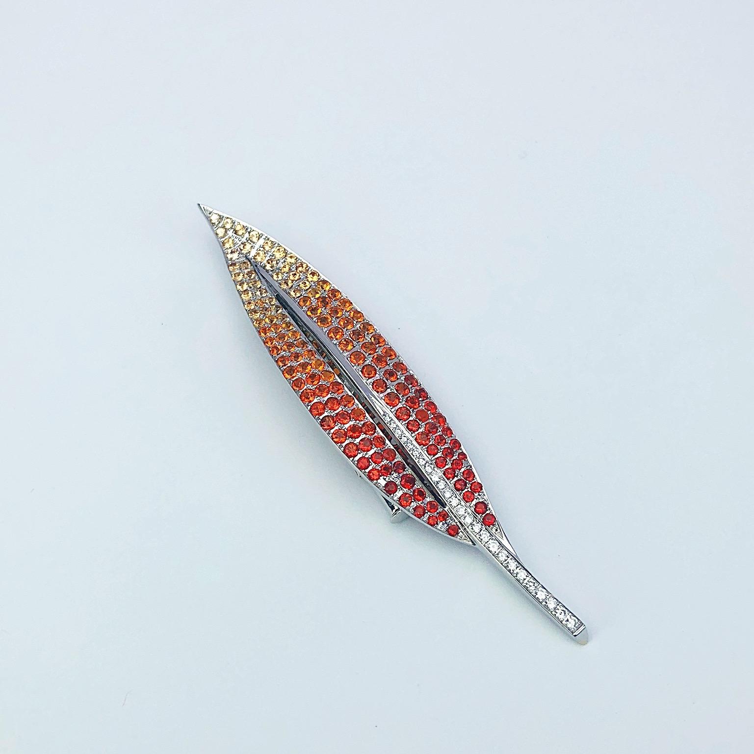 Magnificent 18 karat white gold leaf brooch set with a beautiful palette of ombre' stones. Starting with deep orange fire opals transitioning to lighter shades of yellow sapphires. A row of white diamonds are set in the stem. The brooch measures