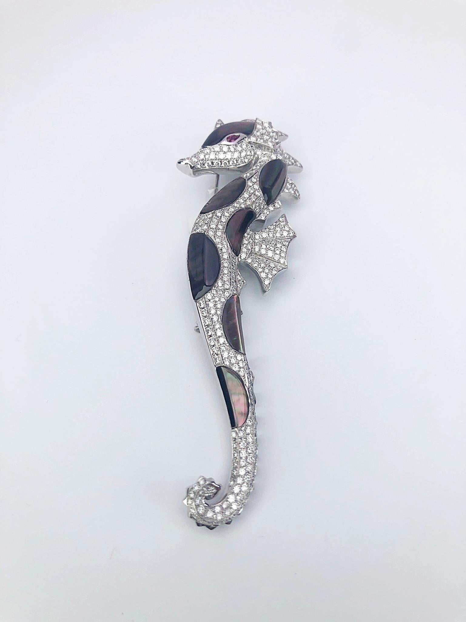 The seahorse is a symbol of luck and good fortune, an attribute of the sea. Considered to be a symbol of strength and power this seahorse brooch is the perfect example. Organic shapes of mother of pearl are set next to diamond pave to create the