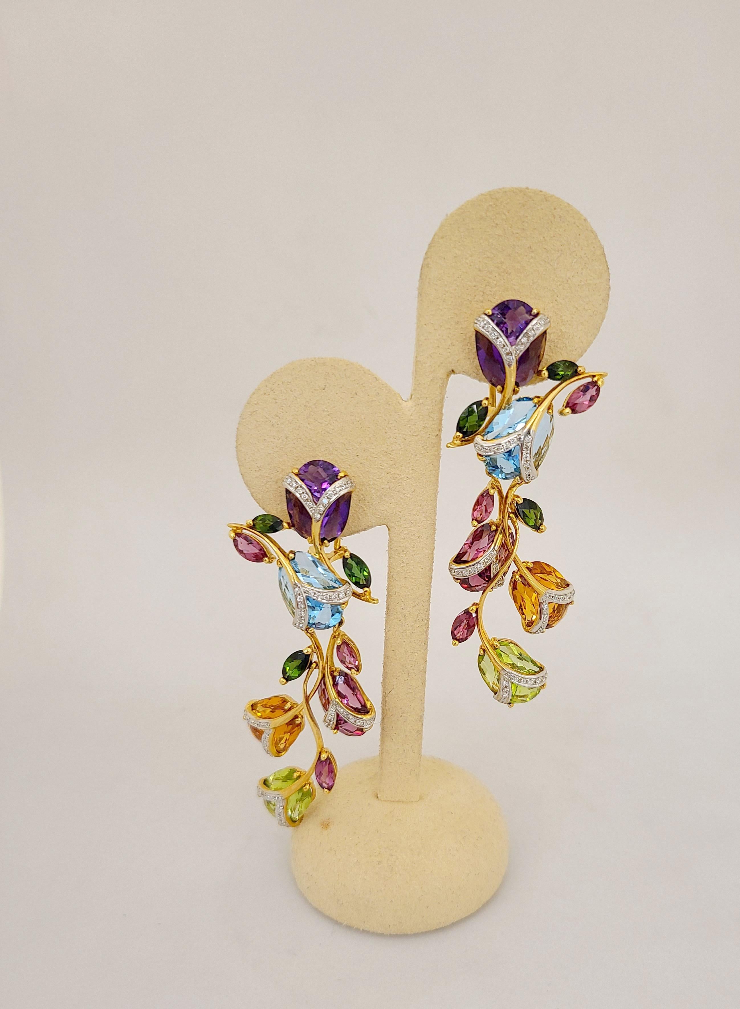 These beautiful Cellini Jewelers NYC elongated 18 karat yellow gold earrings are designed with semi precious stones set in tulip motifs accented with diamonds. The light and airy settings include semi precious stones of amethyst, citrine, blue
