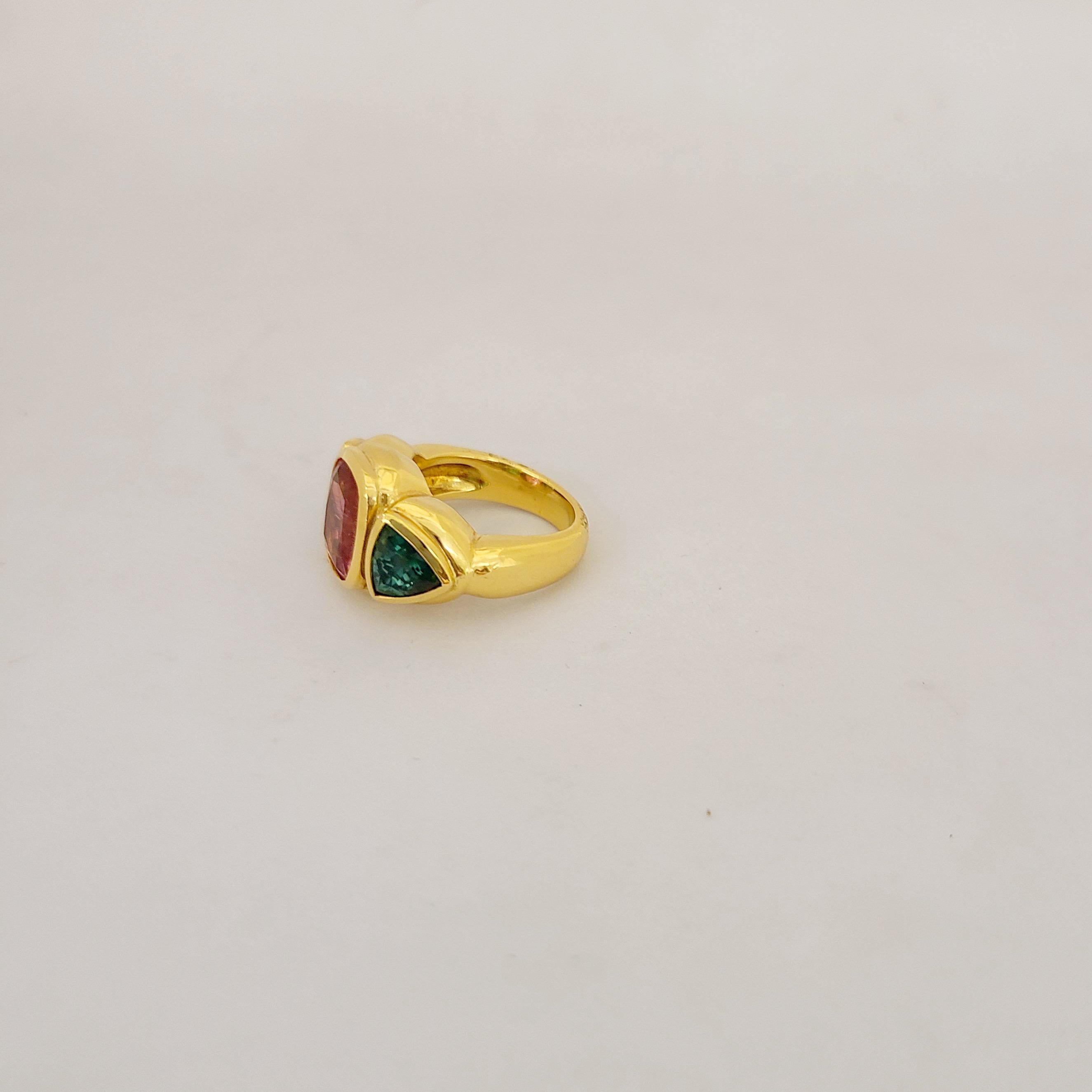 Designed for Cellini this one of a kind ring is set with a cushion shaped rubelite center stone flanked by 2 green tourmaline trillion cut stones. Each stone is set in it's own gold bezel in this lovely handmade mounting.
Total stone weight 6.63