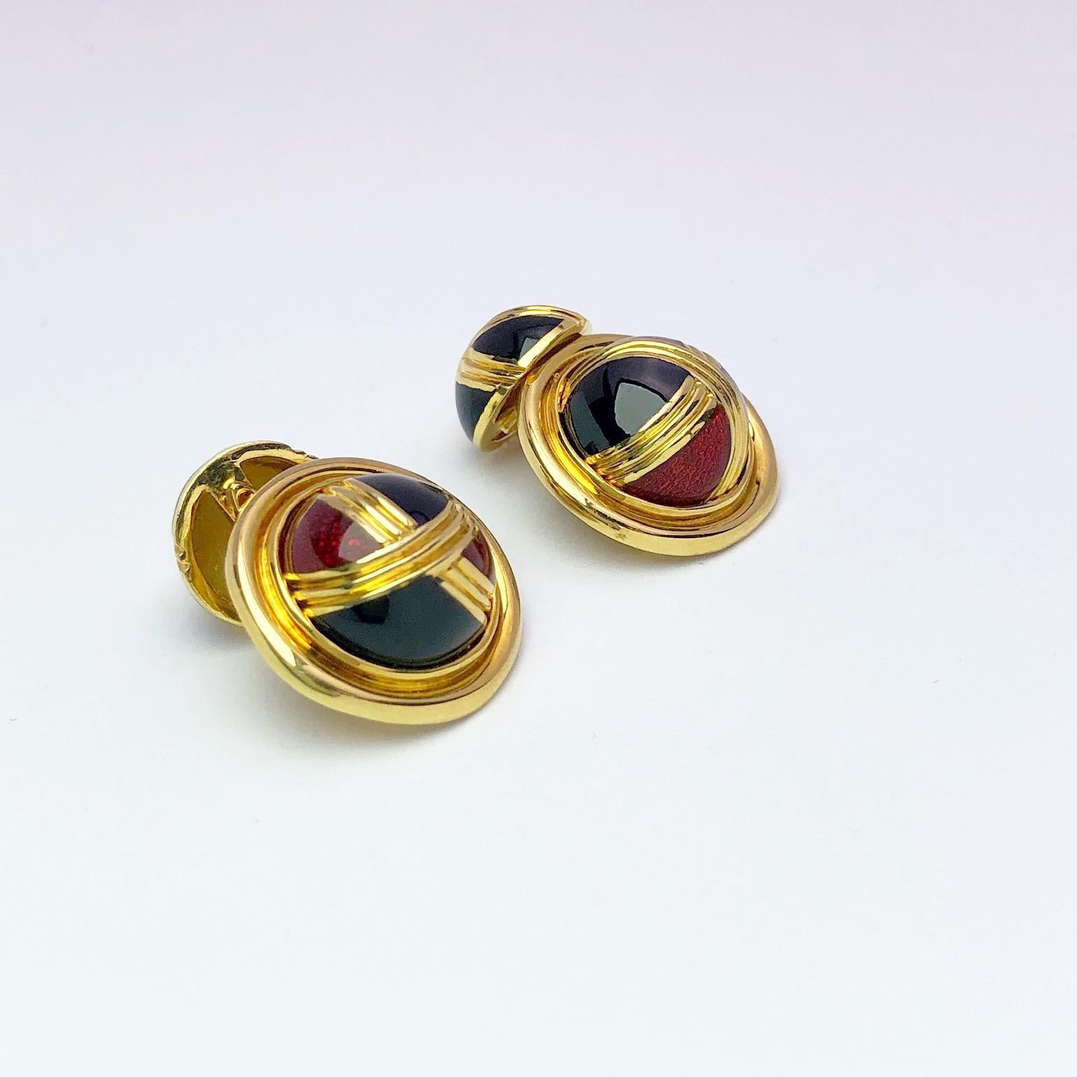 Designed for Cellini Jewelers NYC these 18 karat yellow gold cufflinks are enameled in burgundy and black with gold detailing.  These are the chain style cufflinks with smaller enameled domed backs.
Stamped Cellini 750 along with the jewelers