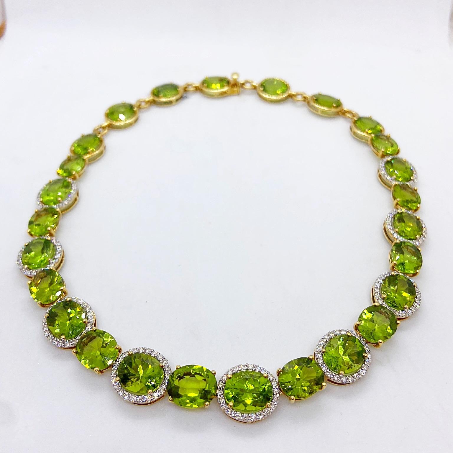 This impressive 18 karat yellow gold necklace has been set with 28 oval Peridot stones. The front 19 Oval Peridots alternate between Diamond bezel set and prong set. The 9 Peridots towards the back are set in yellow gold bezel settings. The total