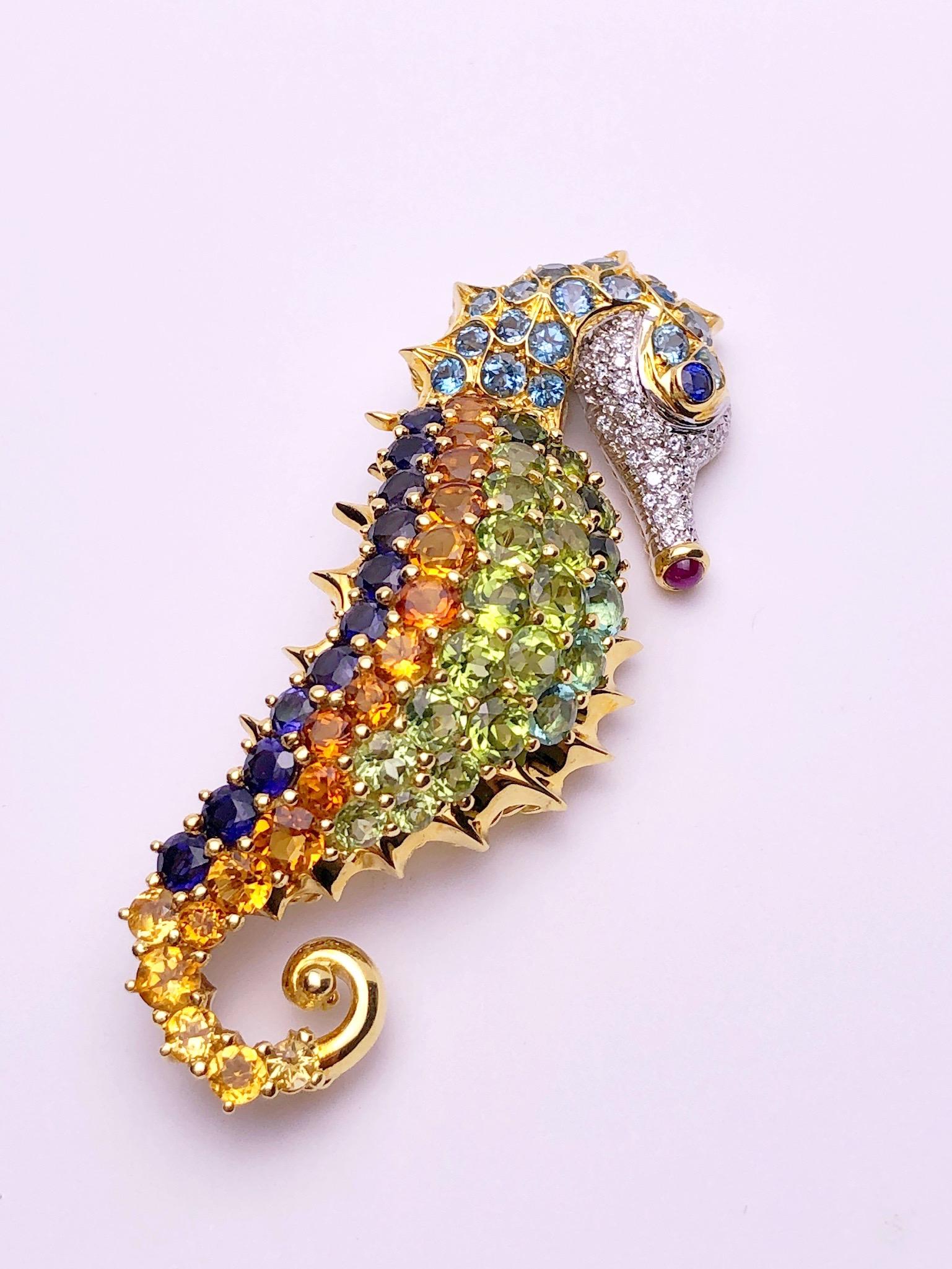 The seahorse is a symbol of luck and good fortune, an attribute of the sea. Considered to be a symbol of strength and power this seahorse brooch is the perfect example. Semi precious round stones in peridot, citrine, iolite and blue topaz are set in