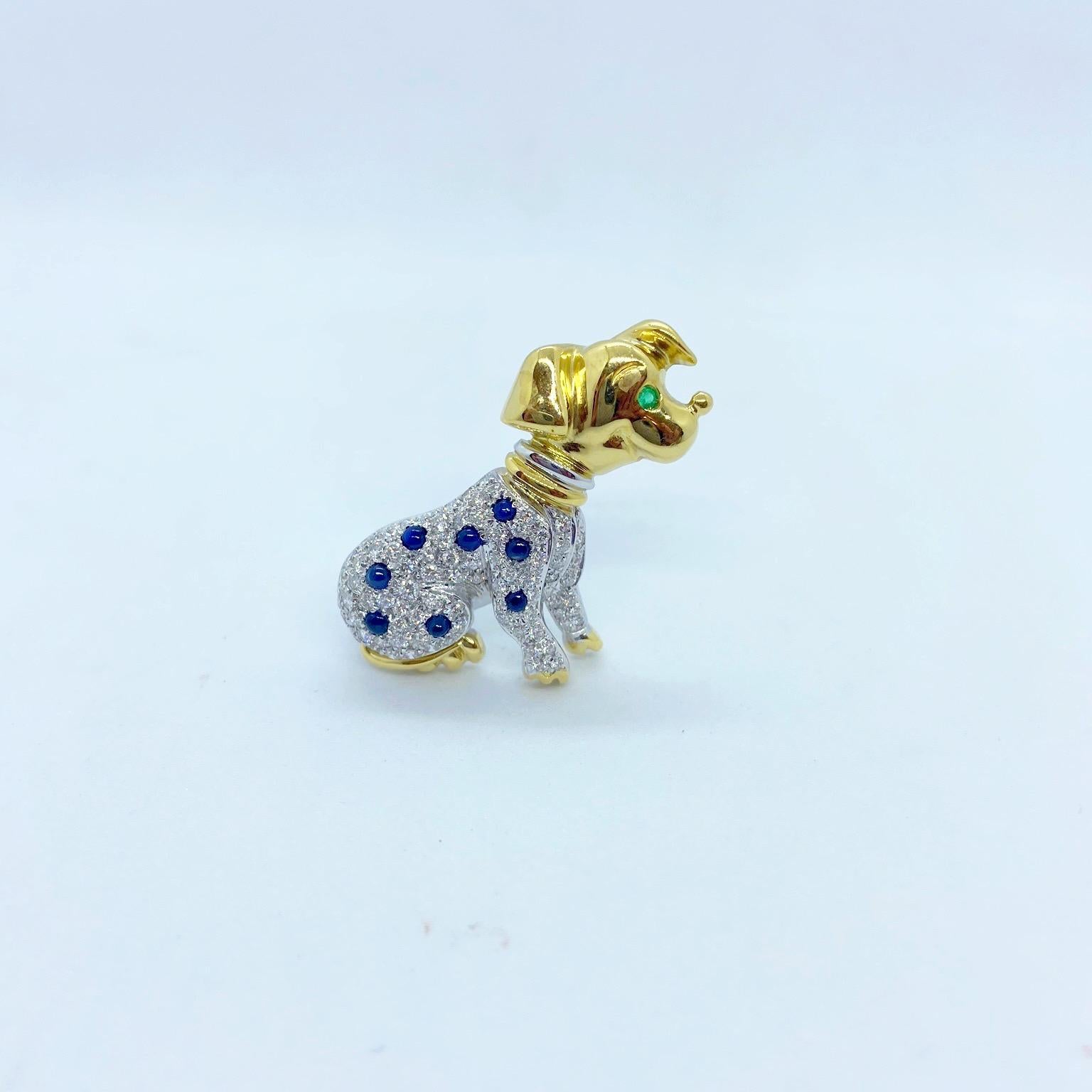 Broche en or 18 carats représentant un dalmatien. Le corps en or blanc est serti de diamants pavés et de saphirs bleus cabochons dispersés. La tête et les pattes sont en or jaune brillant et l'œil est serti d'une émeraude ronde.
Poids du diamant