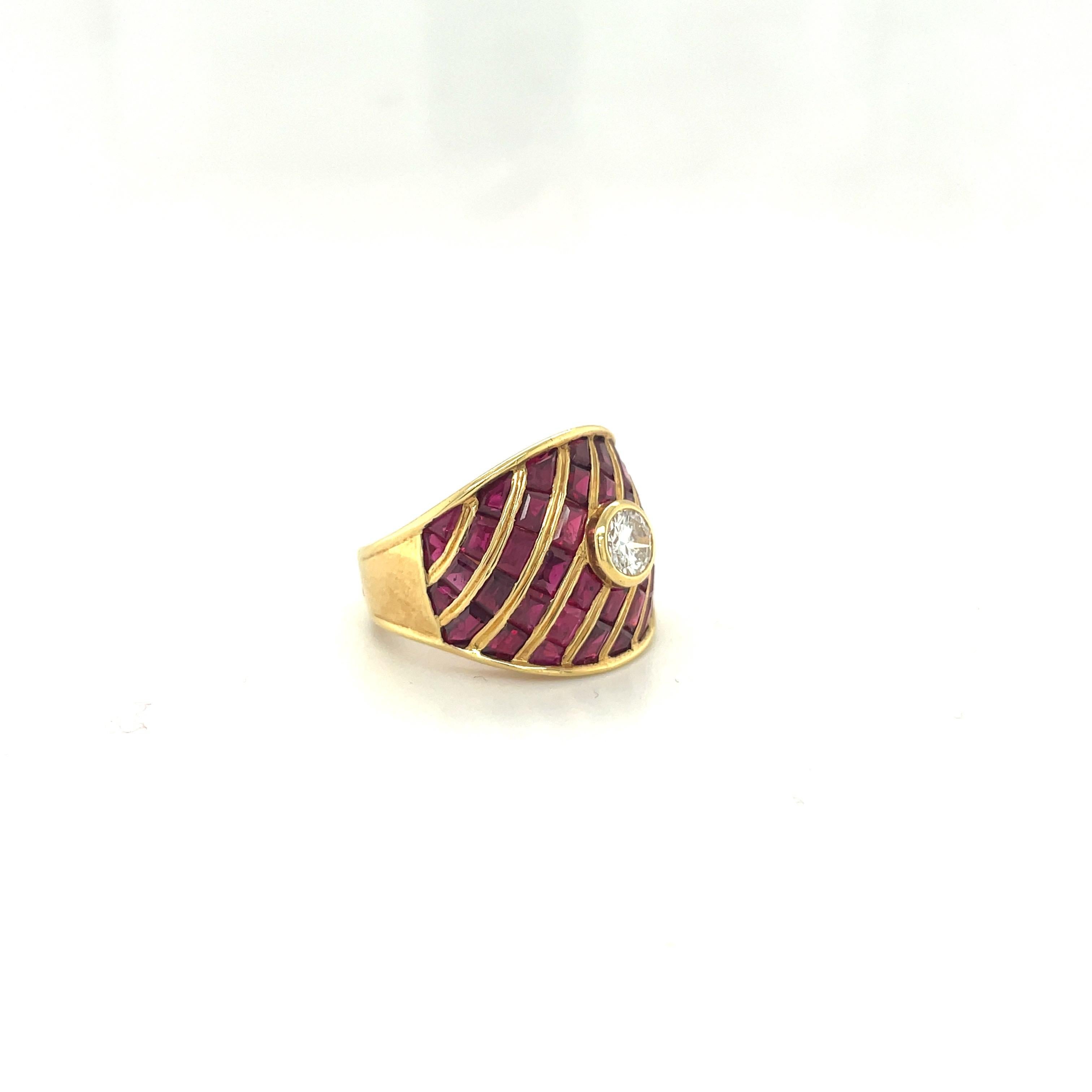 This stunning tapered statement ring is composed of baguette and calibre cut rubies surrounding a single G color round brilliant bezel set diamond, expertly set in 18 karat yellow gold. 
Ruby total carat weight - 6.27cts
Diamond 0.25 carat round