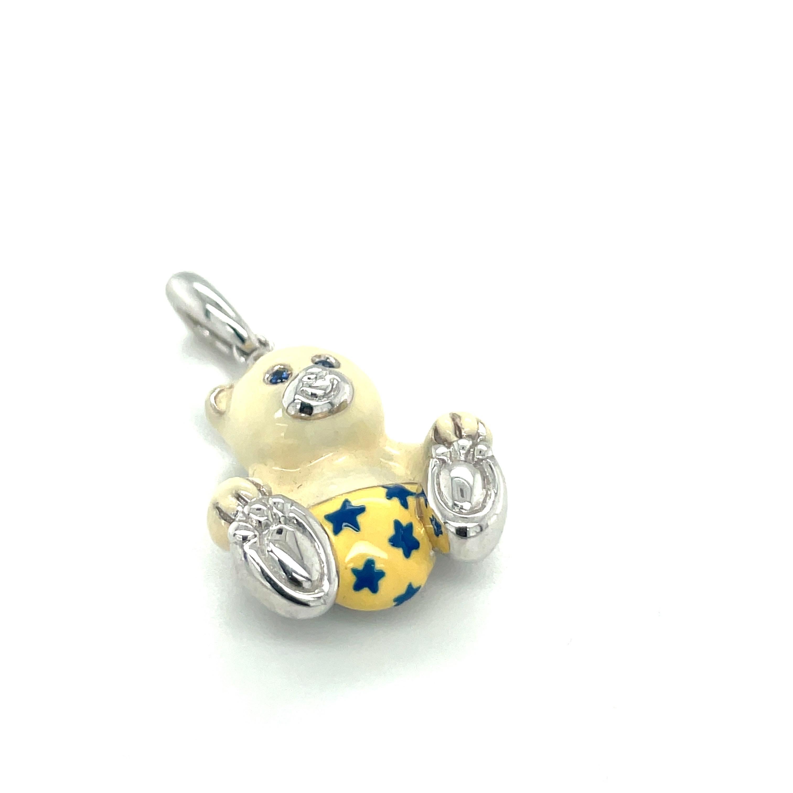 Just the cutest....Teddy bear charm made exclusively for Cellini by Ambrosi of Italy.

This 18 karat white gold teddy bear charm is crafted with a milky white enamel for the body. His outfit is a yellow with blue stars.. He has blue sapphire eyes.