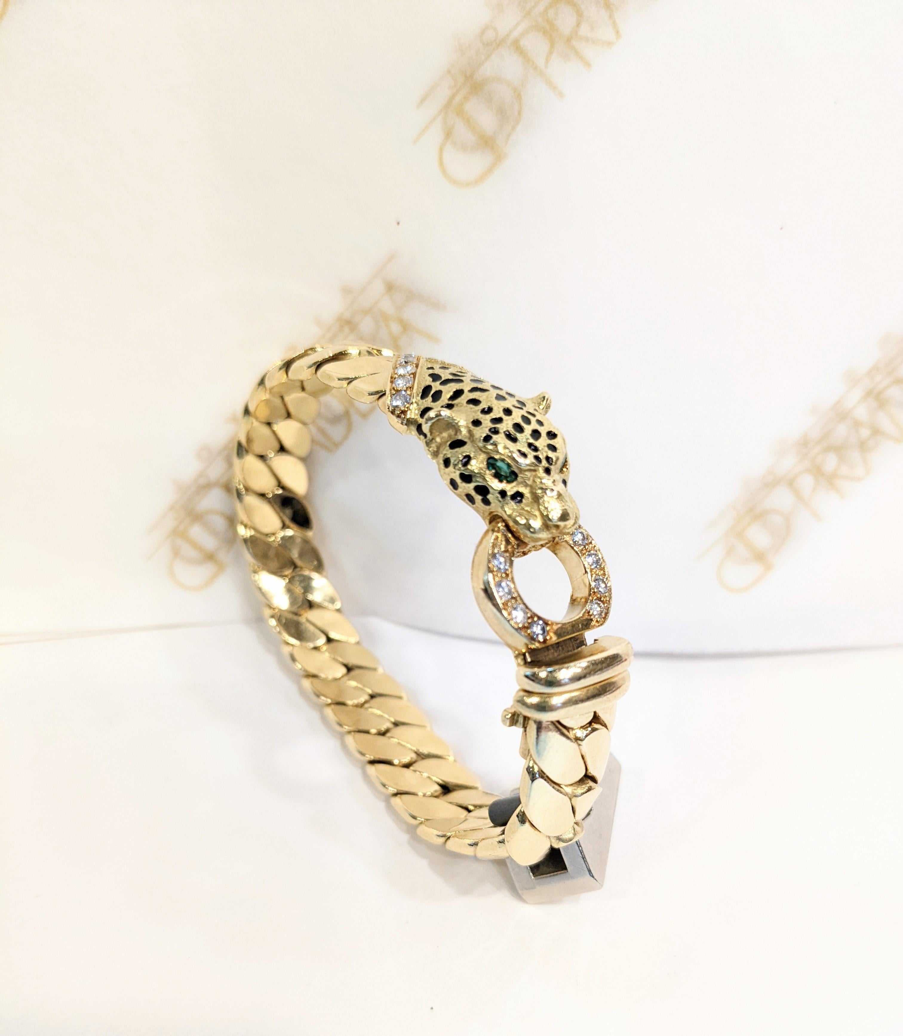 Cellini France
18 karat yellow gold bracelet designed with a shiny gold panther head set with emerald eyes, and black enamel skin.  His neck is set with a square emerald and in his mouth he holds a diamond ring. The central motif is set in a gold